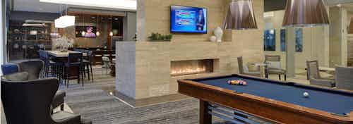 Clubroom at AMLI River North with billiards and a large fireplace as well as a flat screen TV and multiple seating options