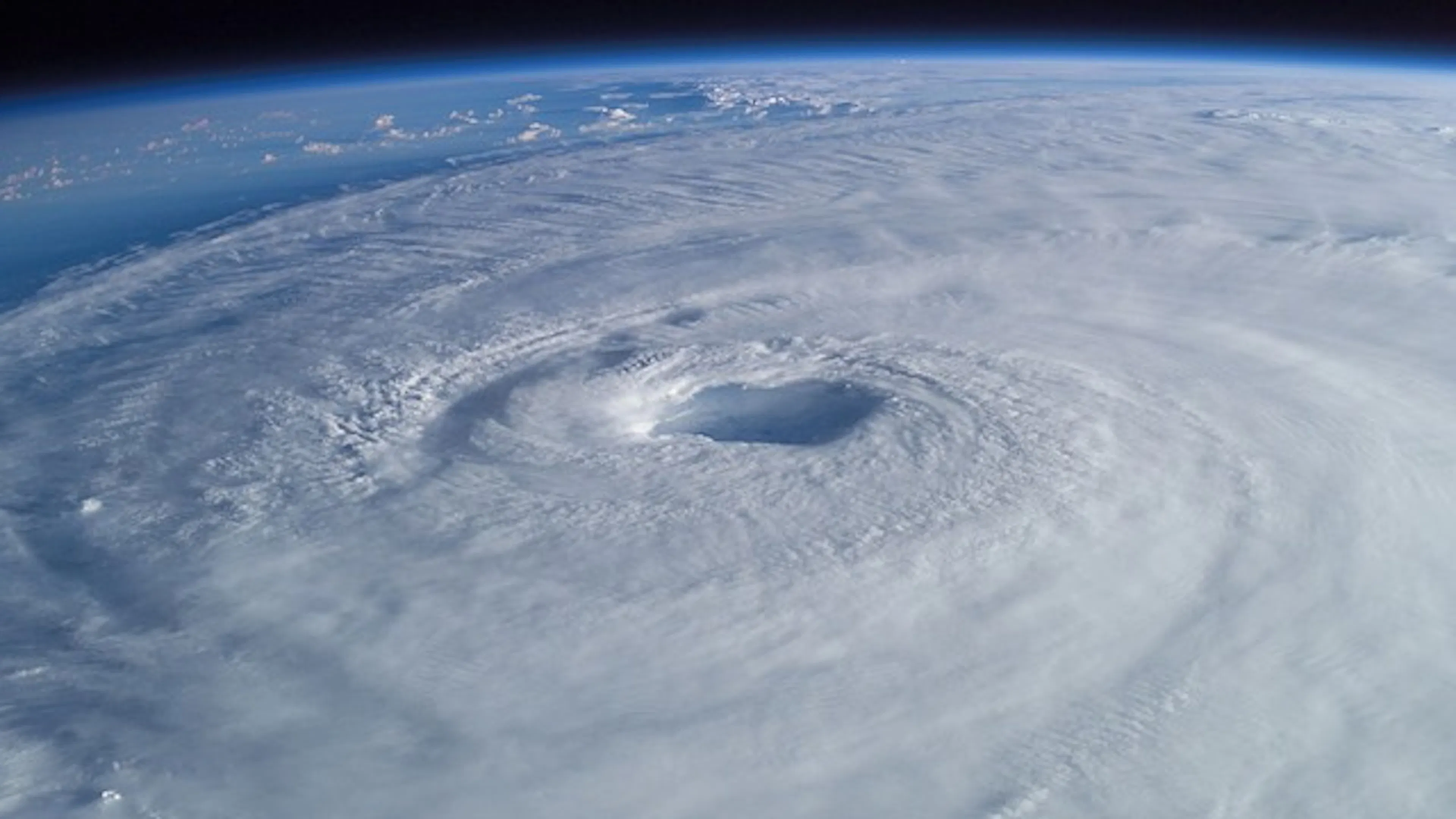 View of a hurricane eye from space with a thick layer of clouds around it