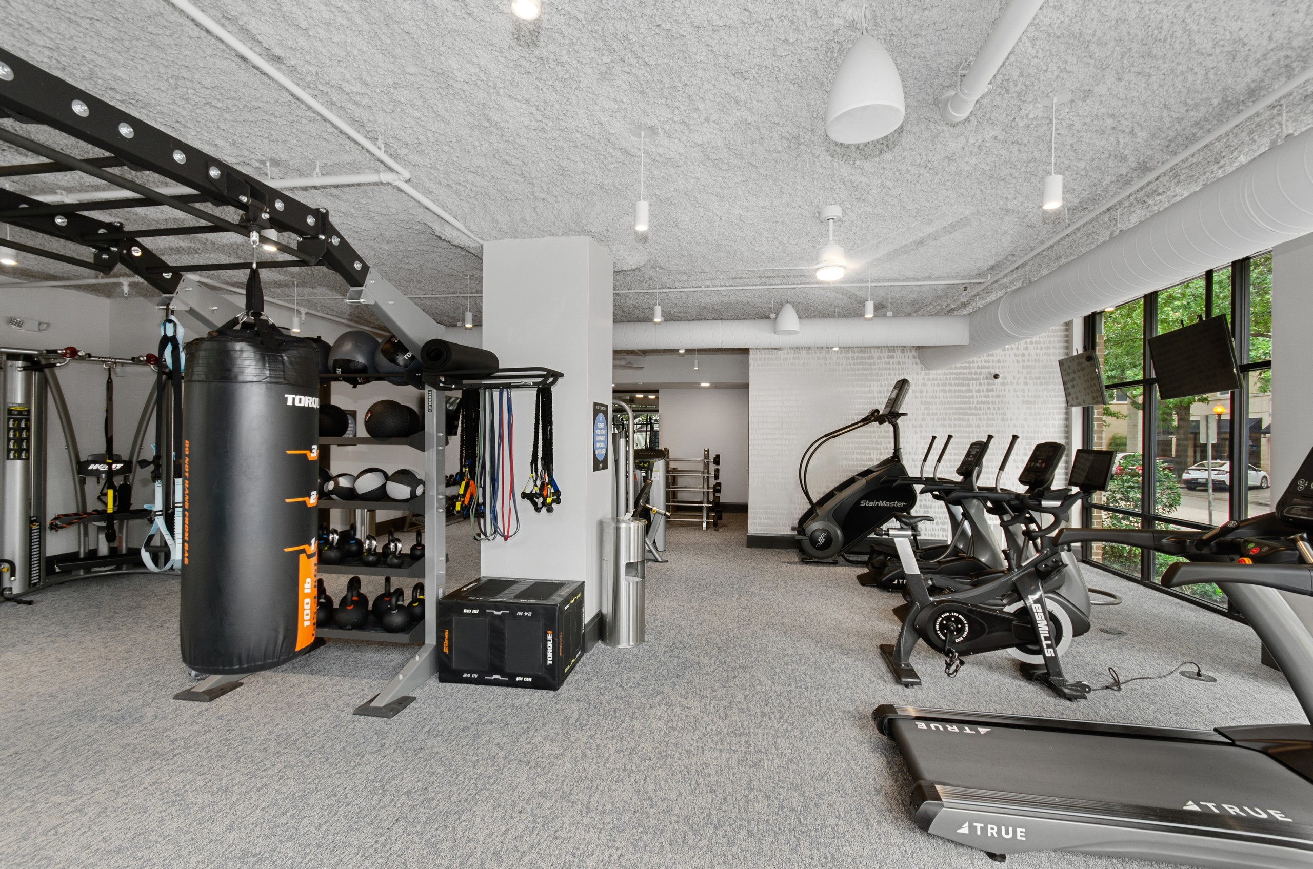 AMLI Quadrangle fitness center with a multipurpose weight training machine and treadmills facing the outside street