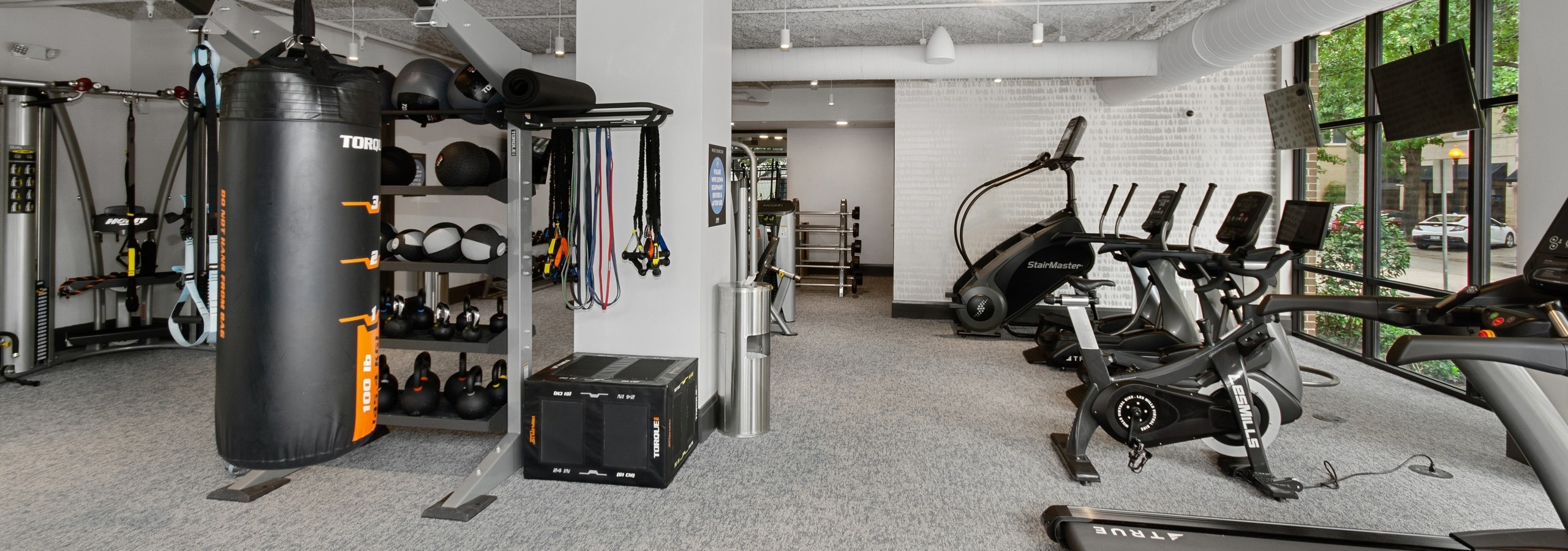 AMLI Quadrangle fitness center with a multipurpose weight training machine and treadmills facing the outside street