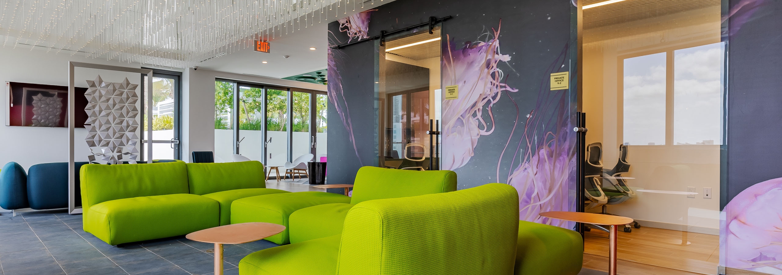 AMLI Midtown Miami resident lounge with green sofas with and ceiling of crystal lights and jellyfish wallpaper and tile floor