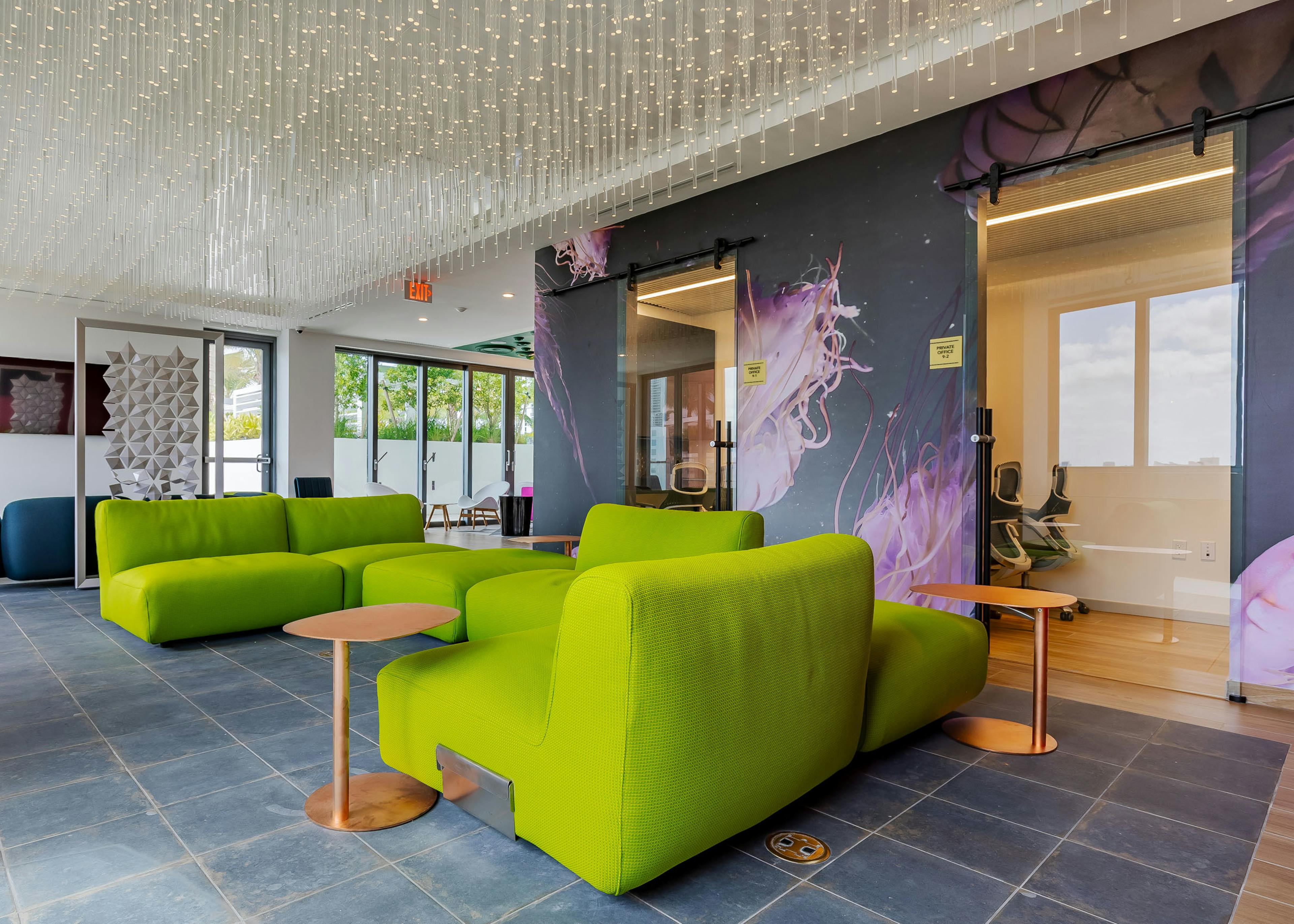 AMLI Midtown Miami resident lounge with green sofas with and ceiling of crystal lights and jellyfish wallpaper and tile floor