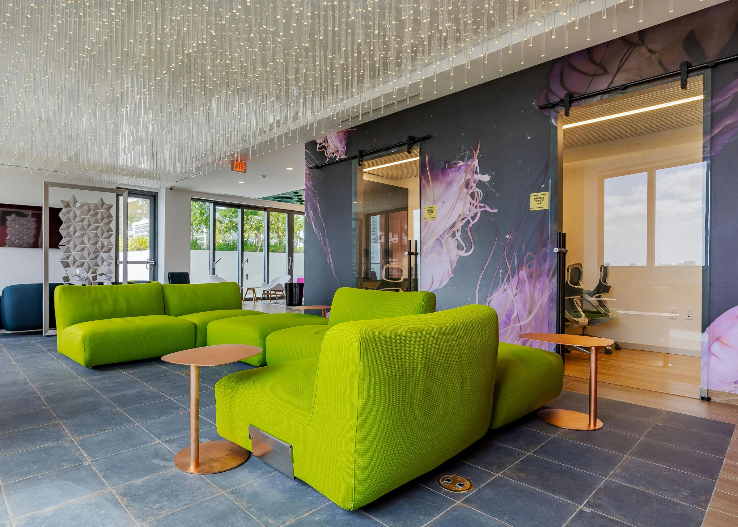 AMLI Midtown Miami resident lounge with green sofas with and ceiling of crystal lights and jellyfish wallpaper and tile floor