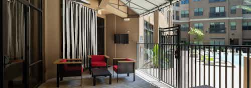 AMLI Uptown aqua lounge overlooking the courtyard pool featuring outdoor HDTV and seating areas with red cushions