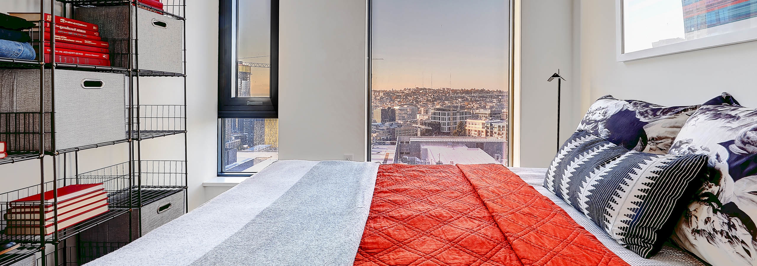 Interior view of apartment of AMLI Arc bedroom with white walls large window with view and space for a queen bed