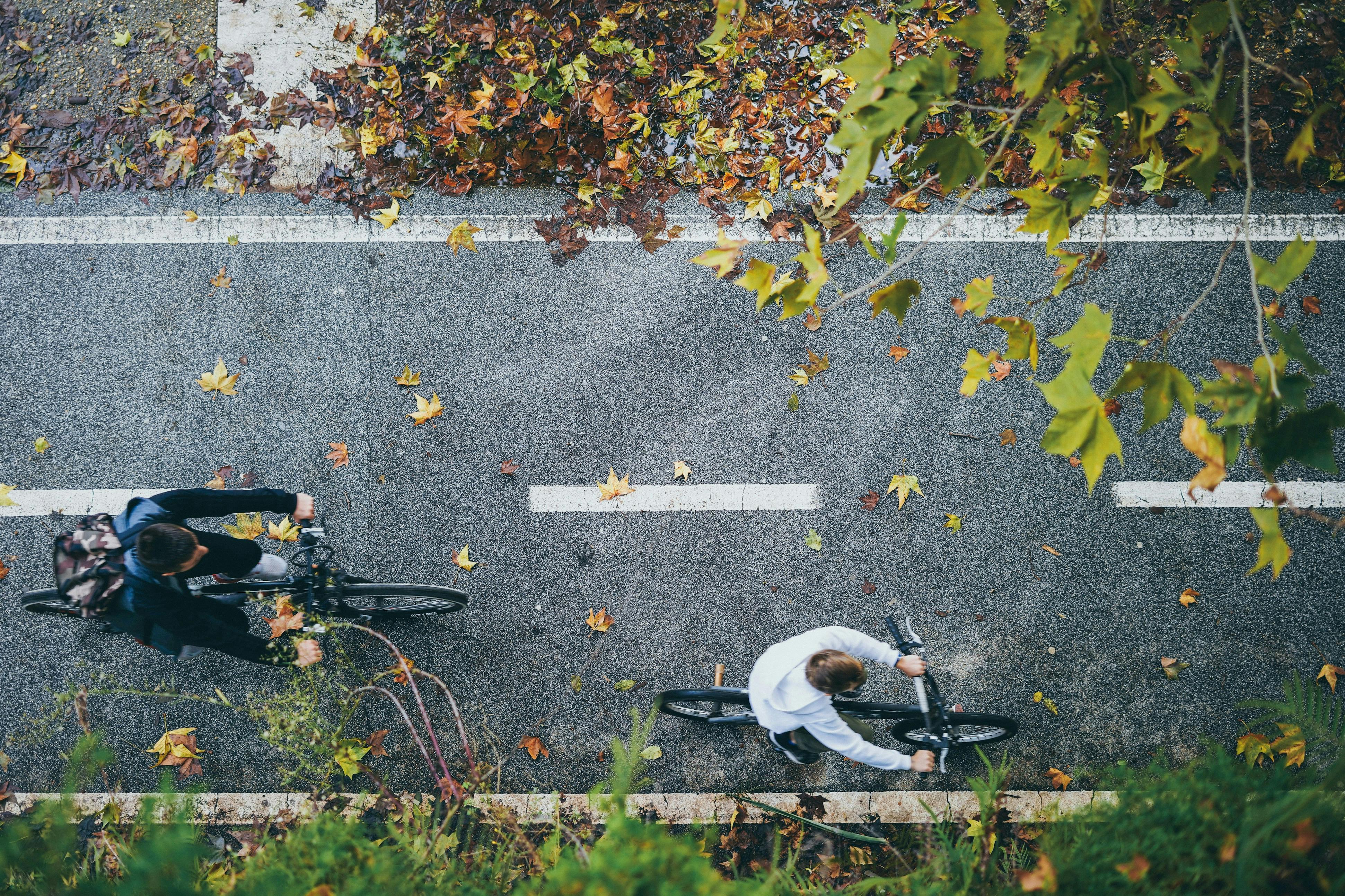 An aerial view of two cyclists on a bike path