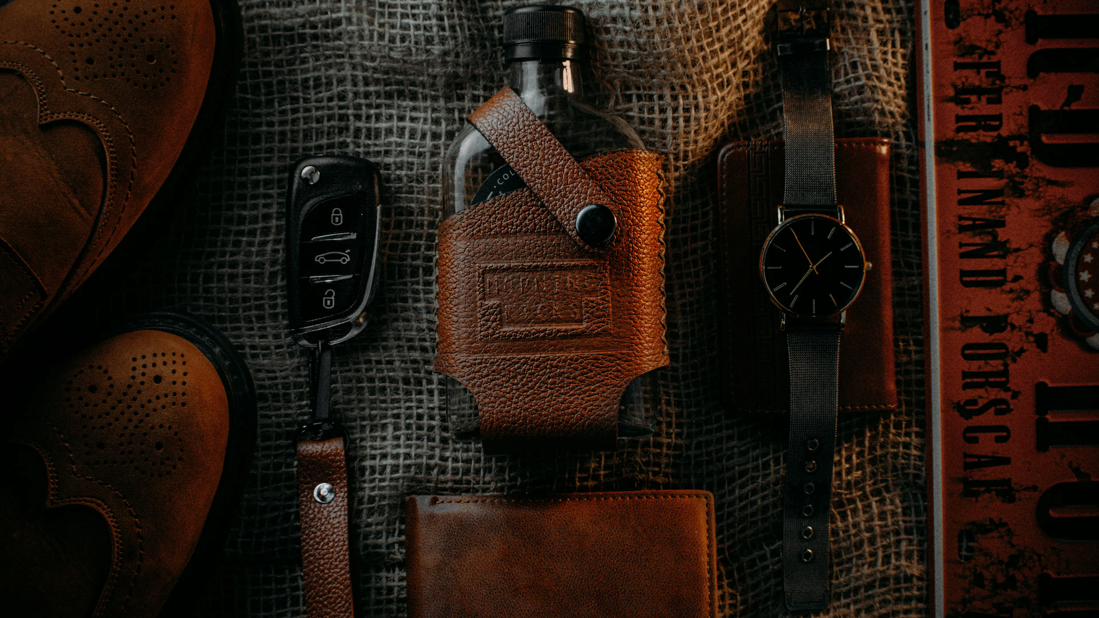 A flask cover and keychain made from leather goods