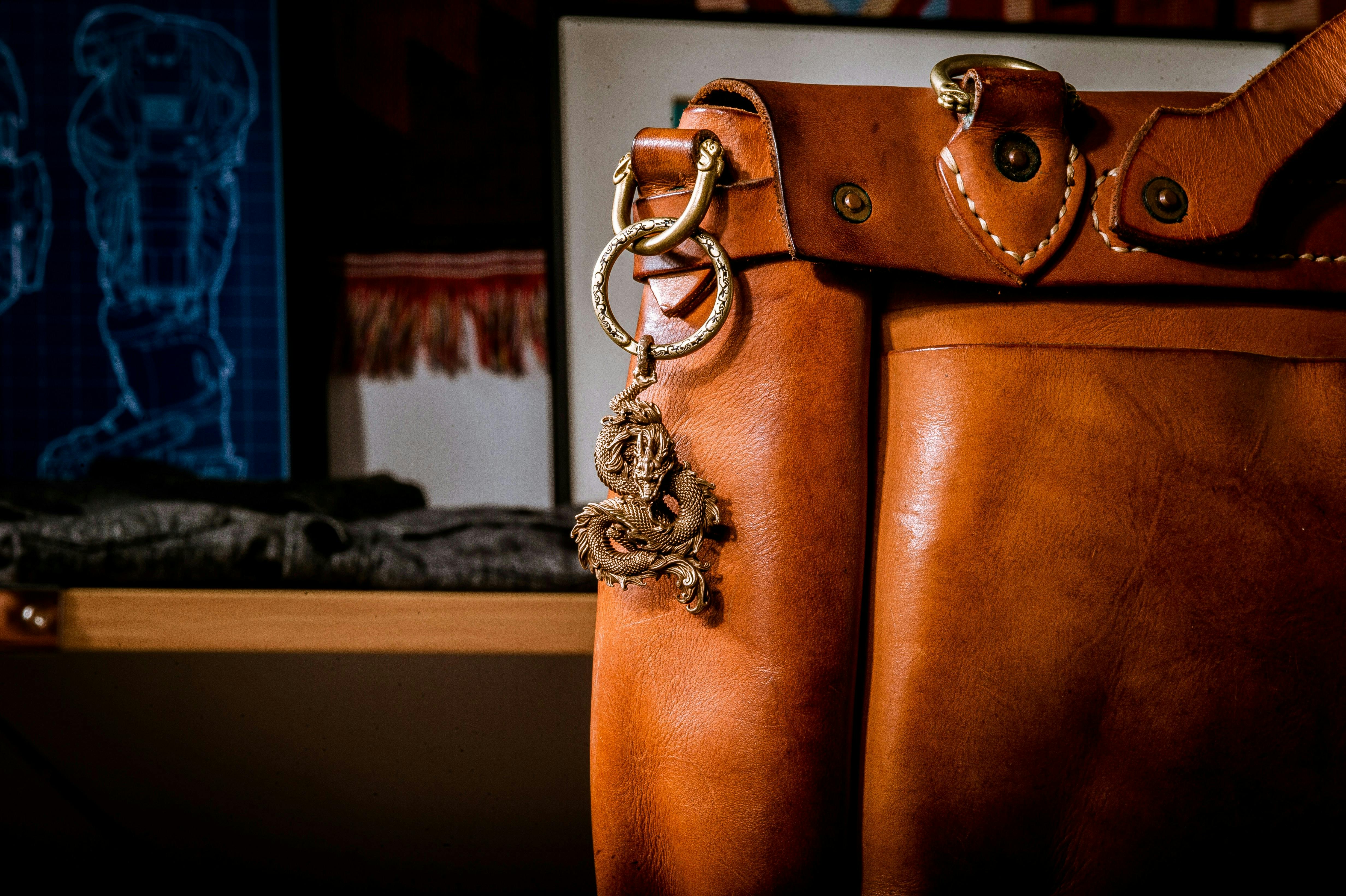 A leather bag with a metal dragon on a keychain