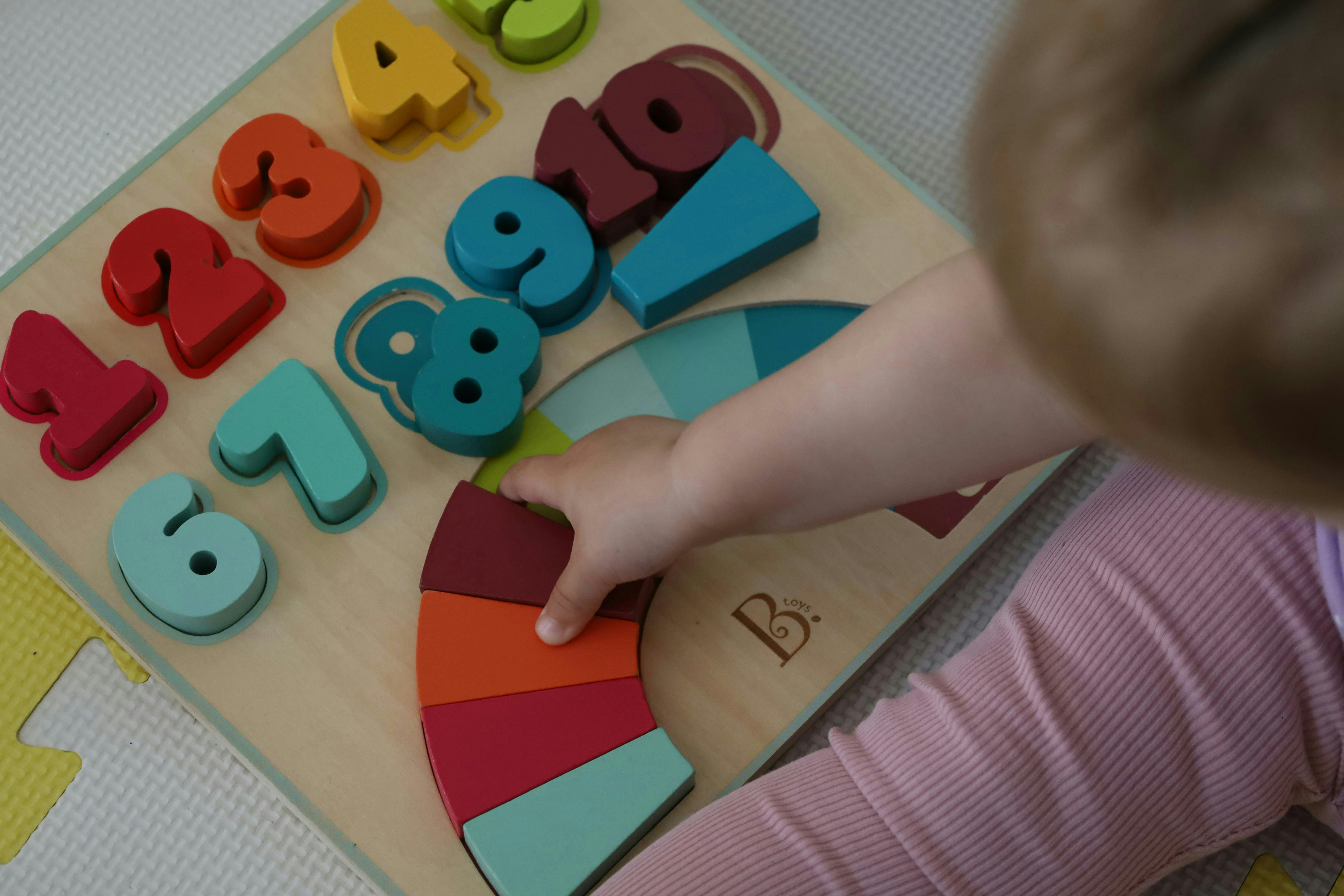 A child playing with blocky numbers on a play mat