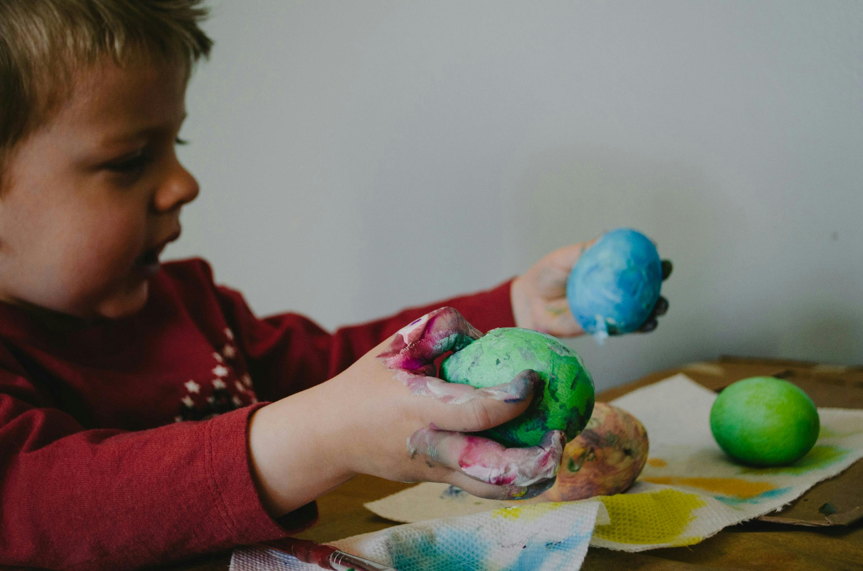 Boy holding blue and green lay dough clay