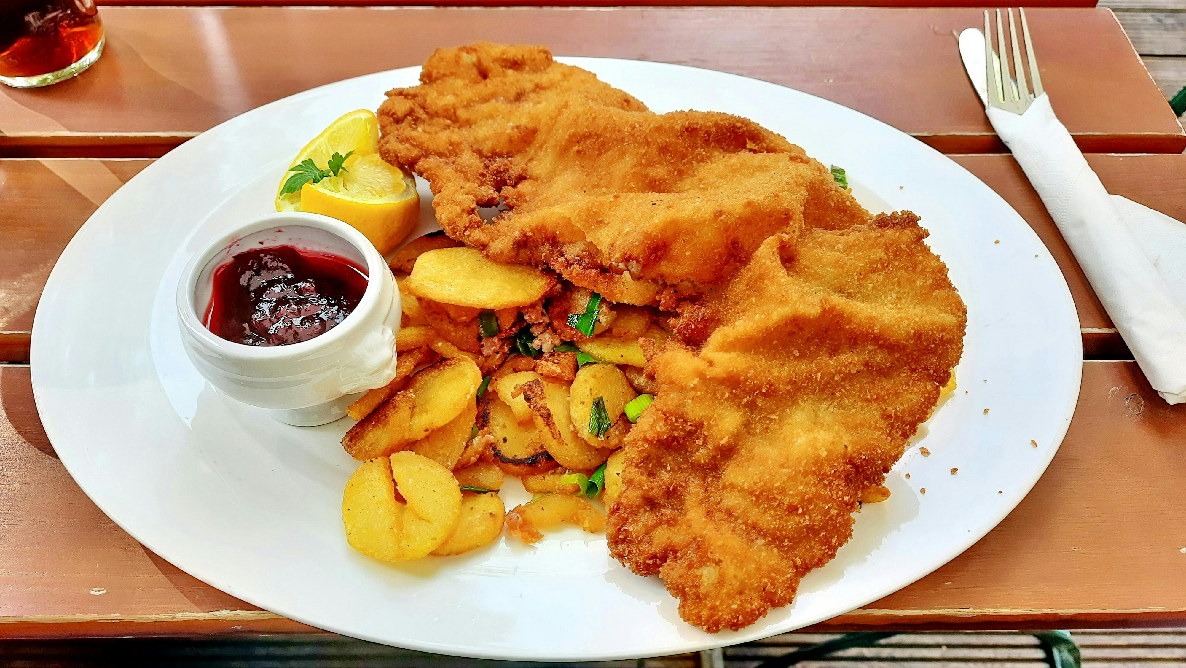 A white plate with schnitzel on it
