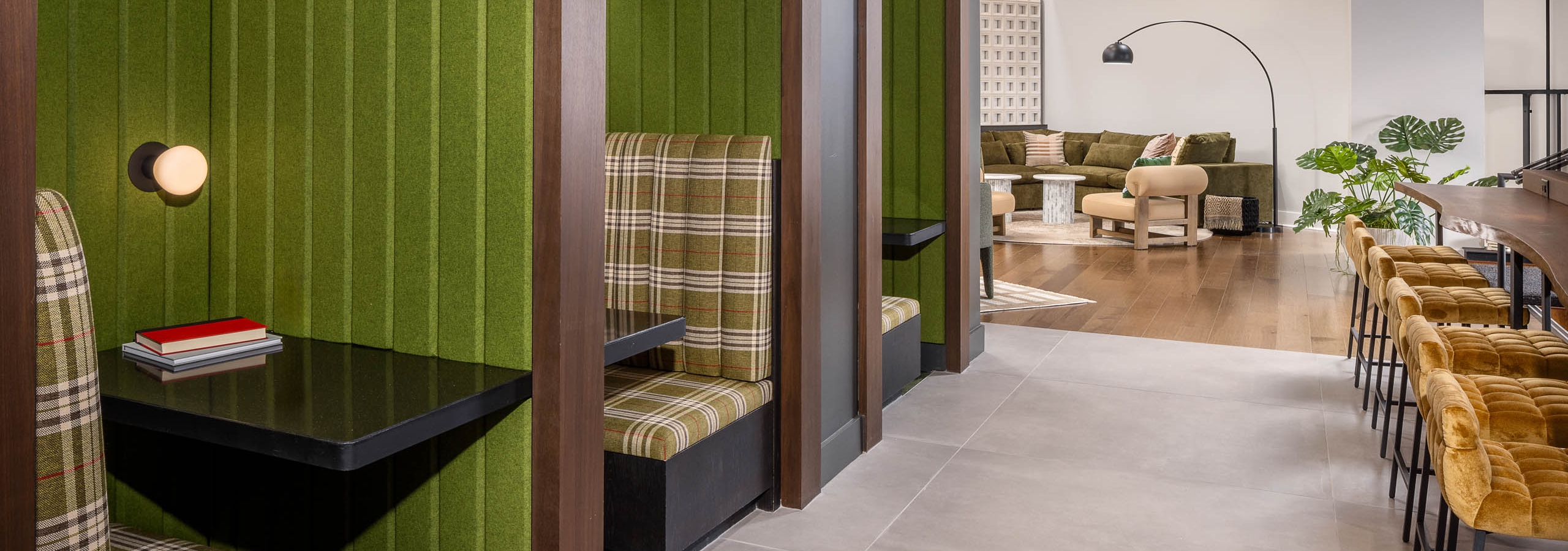AMLI Brookhaven coworking area with individual plaid and green booths with tables and large tile and wooden flooring