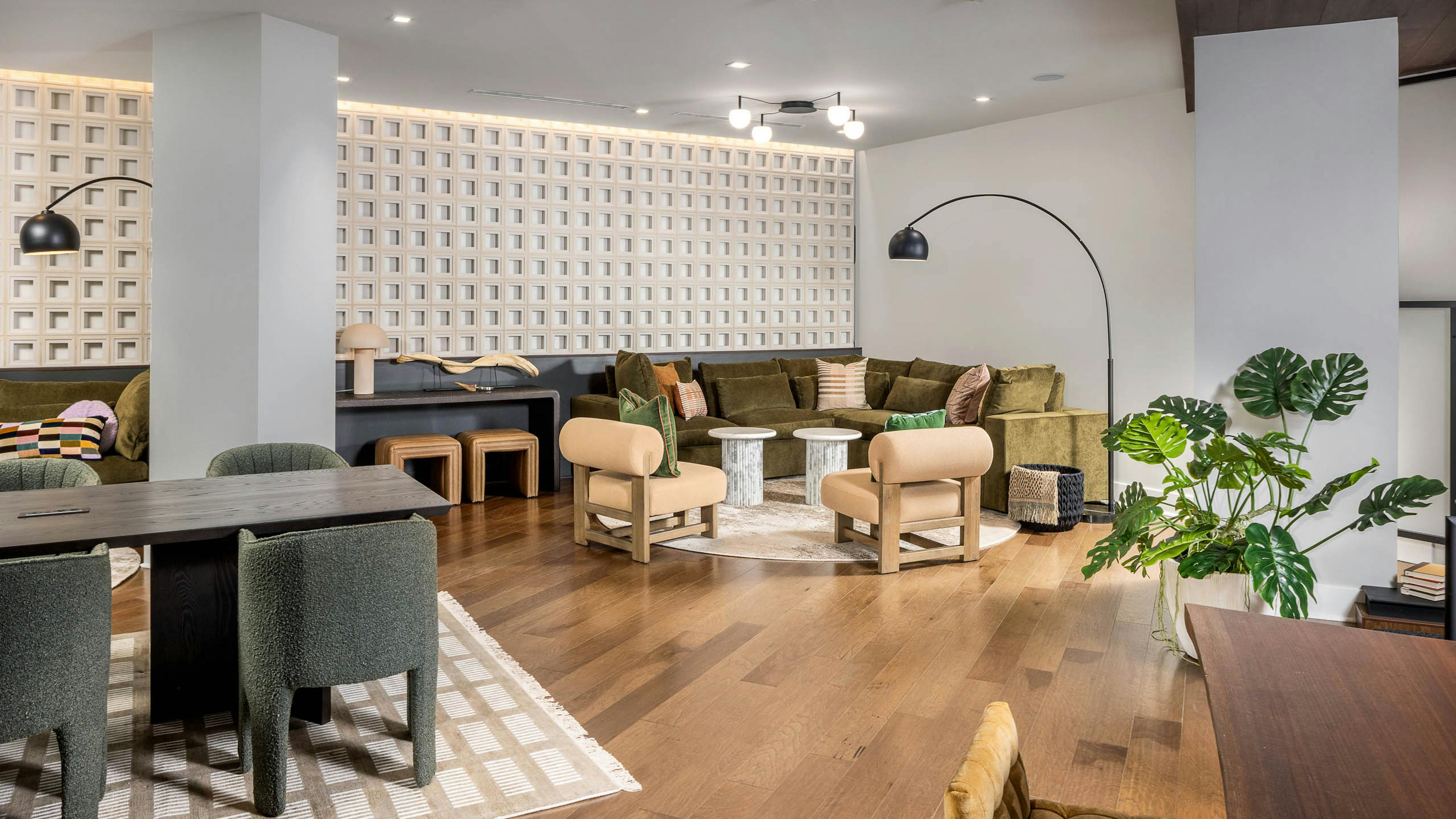 Interior view of a lounge at AMLI Brookhaven with hardwood flooring and floor plants and multiple seating areas with desks