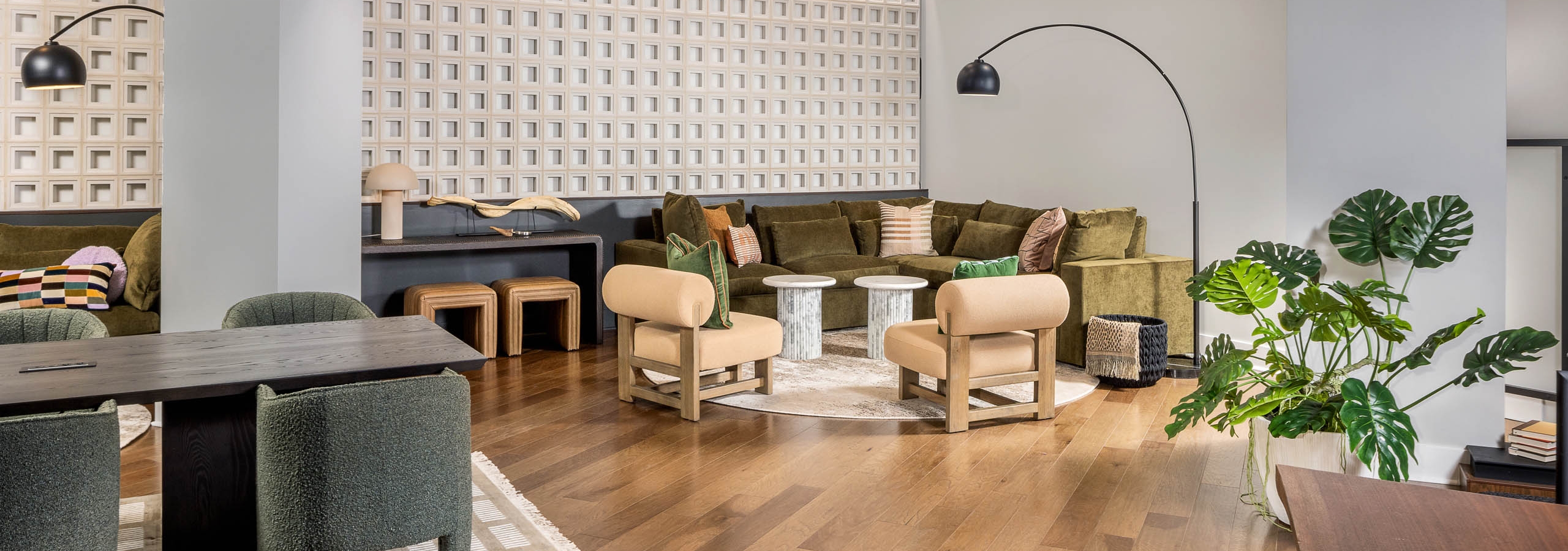 Interior view of a lounge at AMLI Brookhaven with hardwood flooring and floor plants and multiple seating areas with desks
