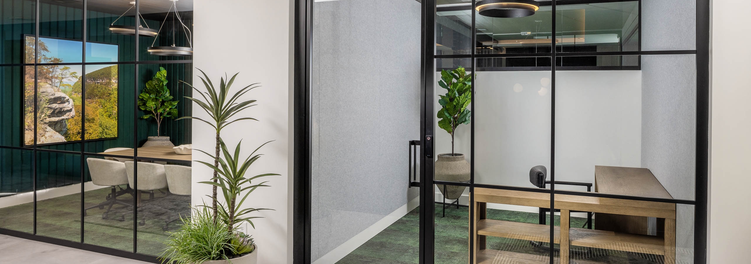 Private office and conference room at AMLI Brookhaven with floor to ceiling windows with black and green carpeting and wood furniture