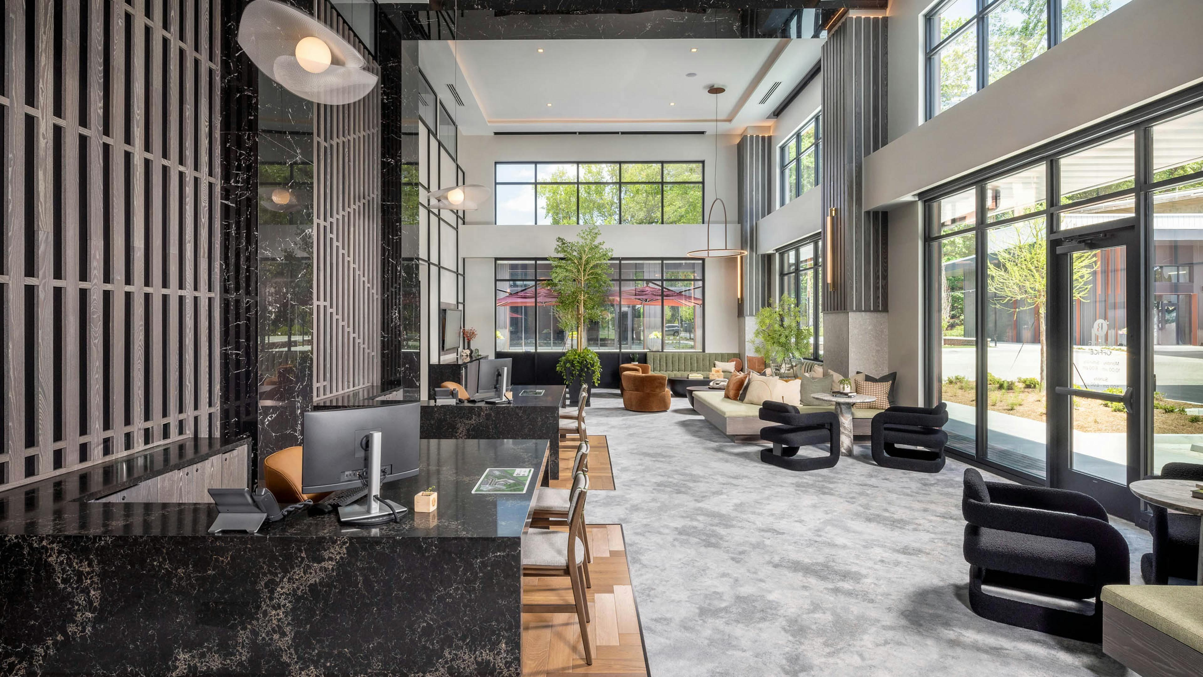 Leasing office at AMLI Brookhaven apartments with two marble desks with computers and vertical dark wood slatted walls
