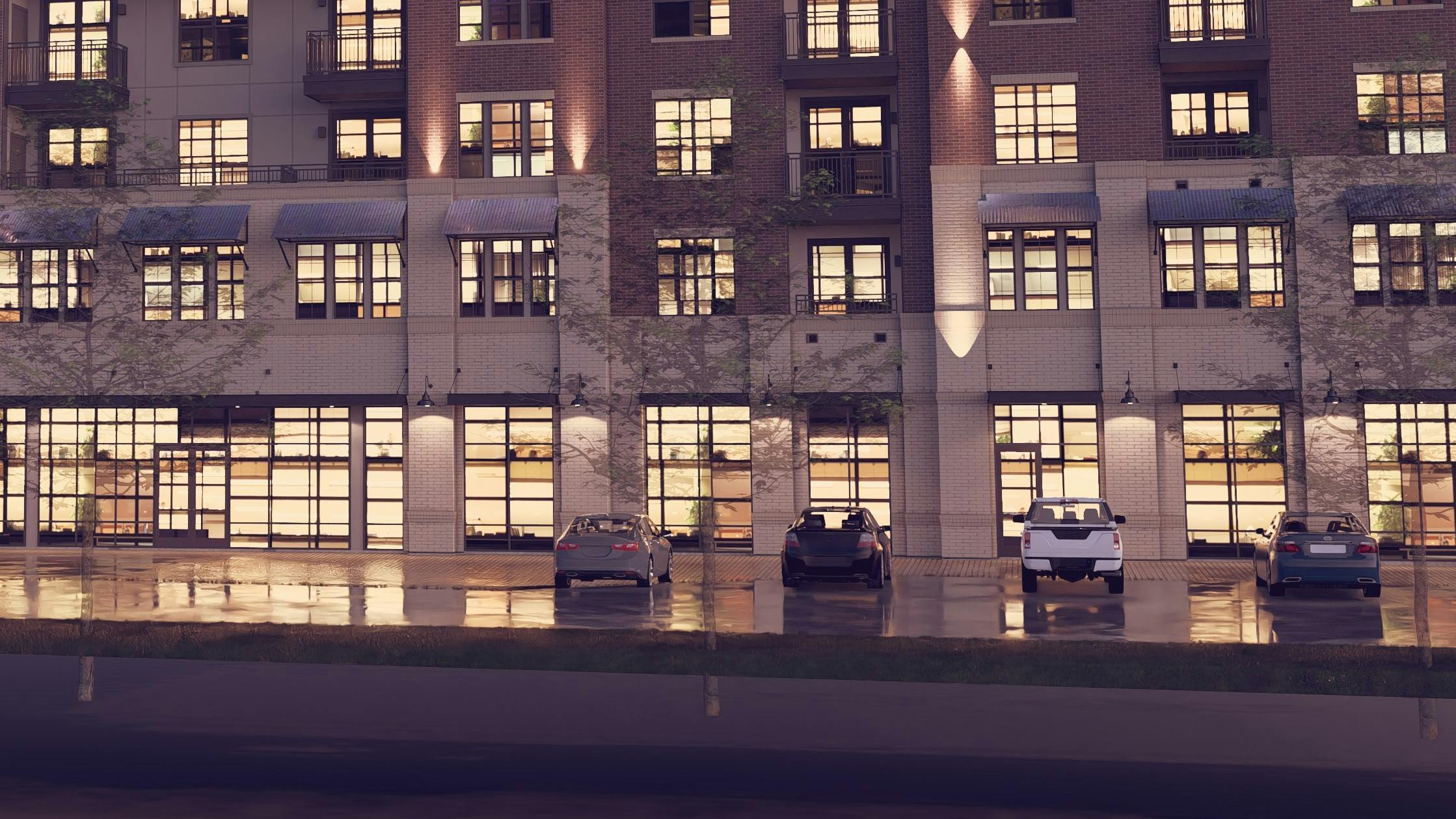 Rendering of AMLI Treehouse apartment building exterior close up at night with brown brick façade with parked cars and lit windows