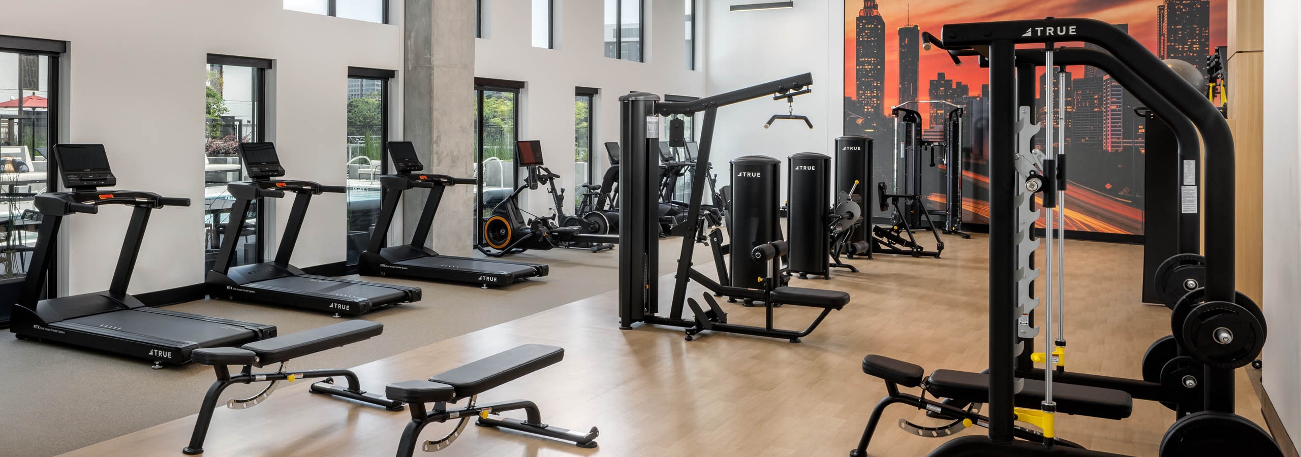 AMLI Atlantic Station’s fitness center with equipment facing a wall of windows.