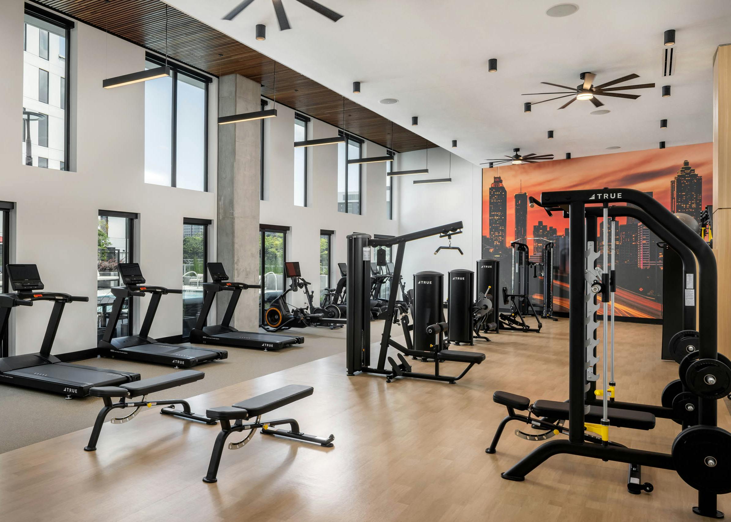 AMLI Atlantic Station’s fitness center with equipment facing a wall of windows.