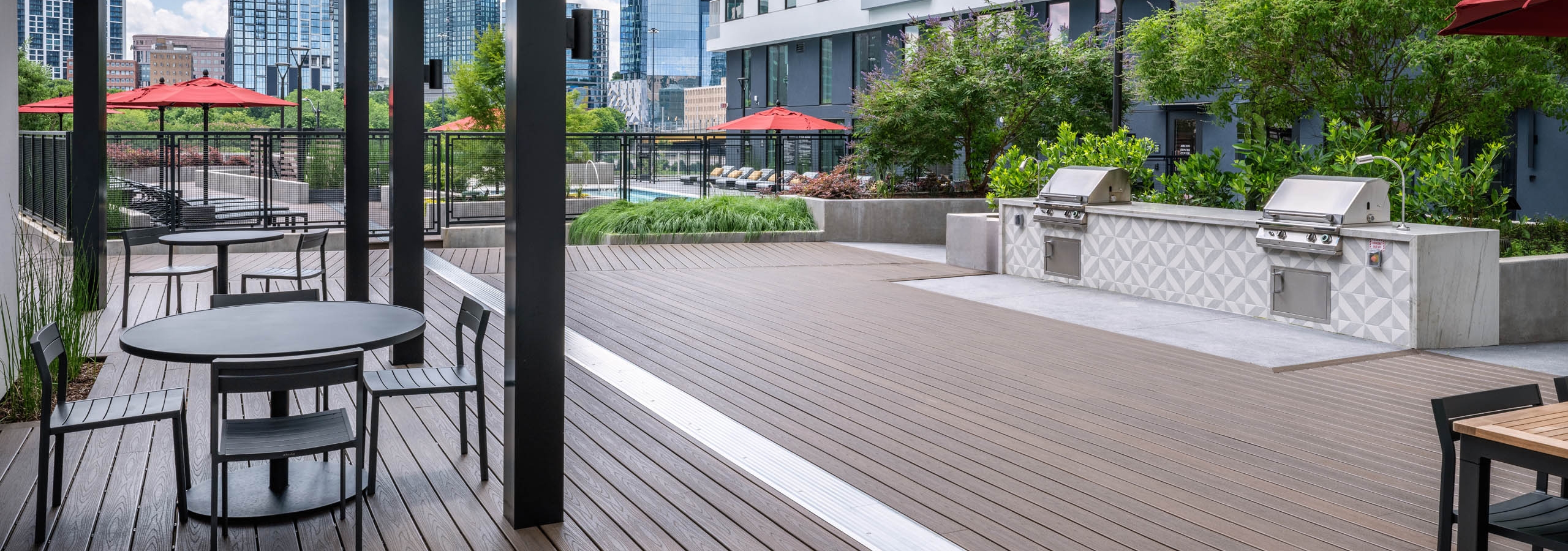 Courtyard at AMLI Atlantic Station with two grills and outdoor tables and seating.