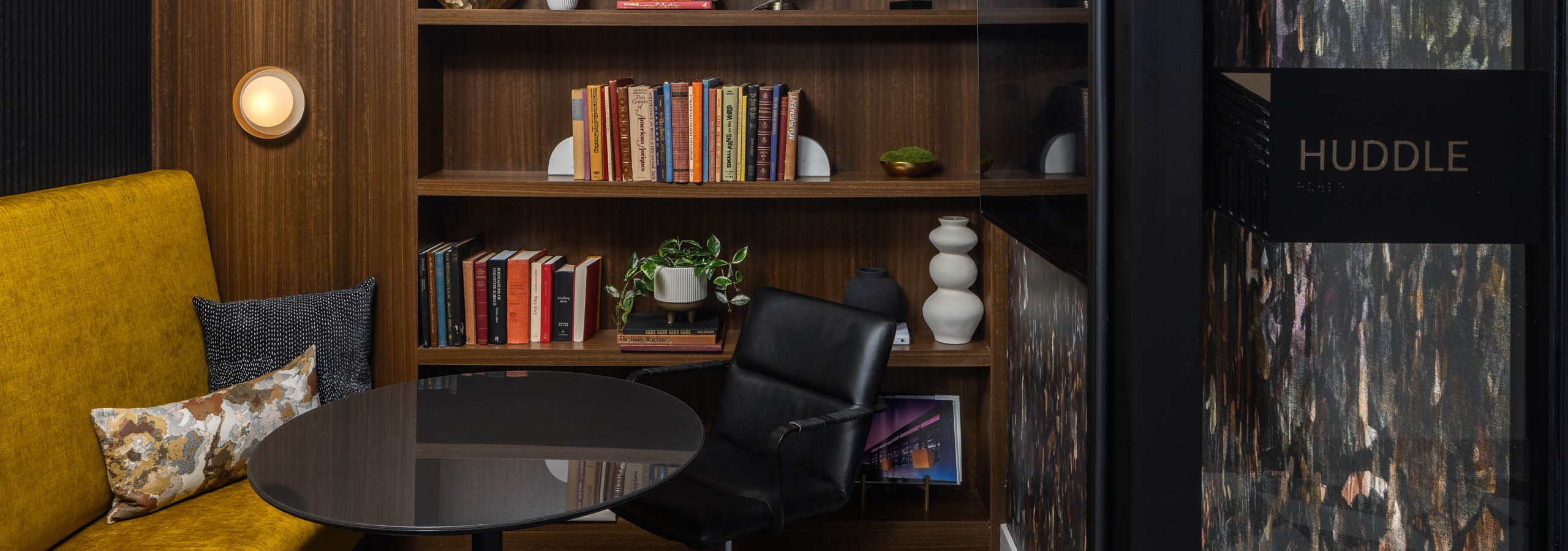 Library room labeled Huddle with a bench and built in shelves at AMLI Atlantic Station.