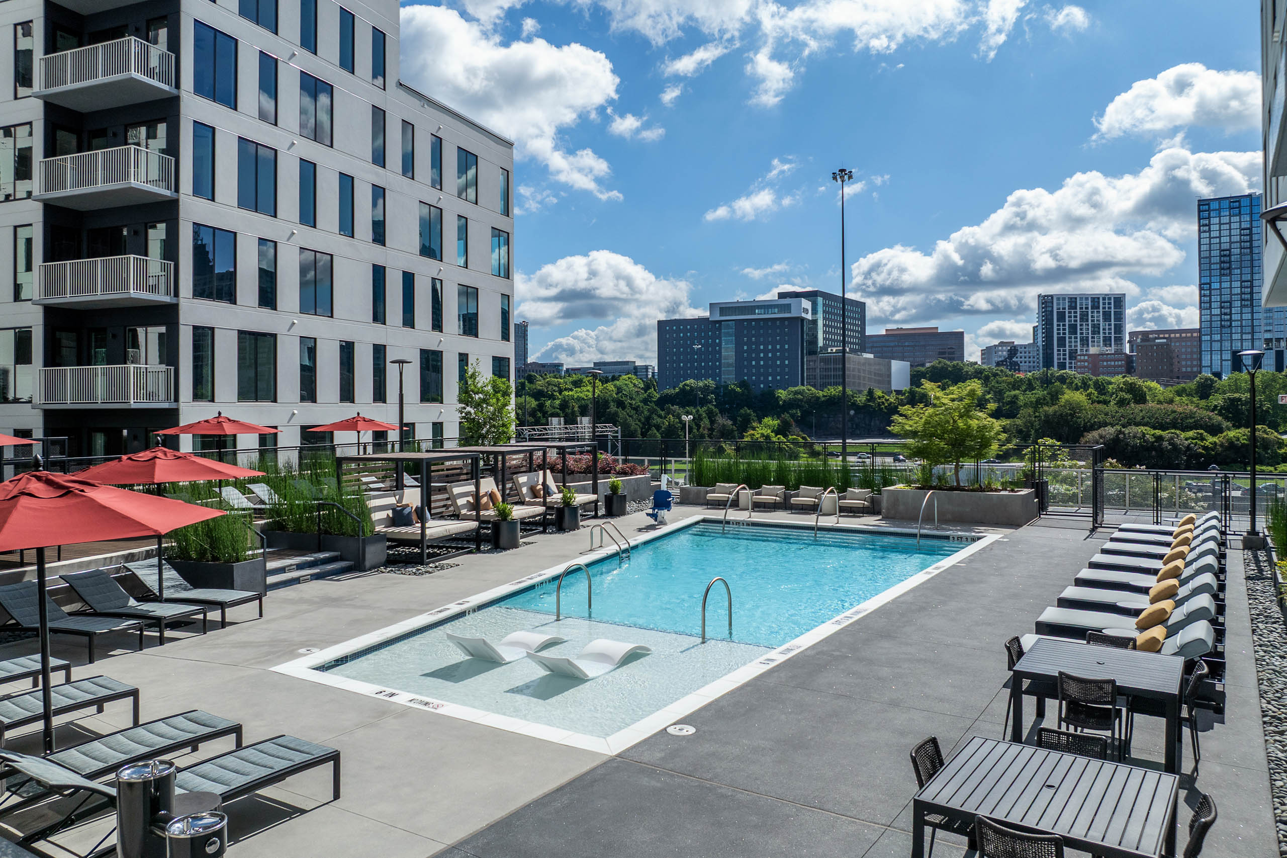 Daytime swimming pool with lounge seating and umbrellas at AMLI Atlantic Station.