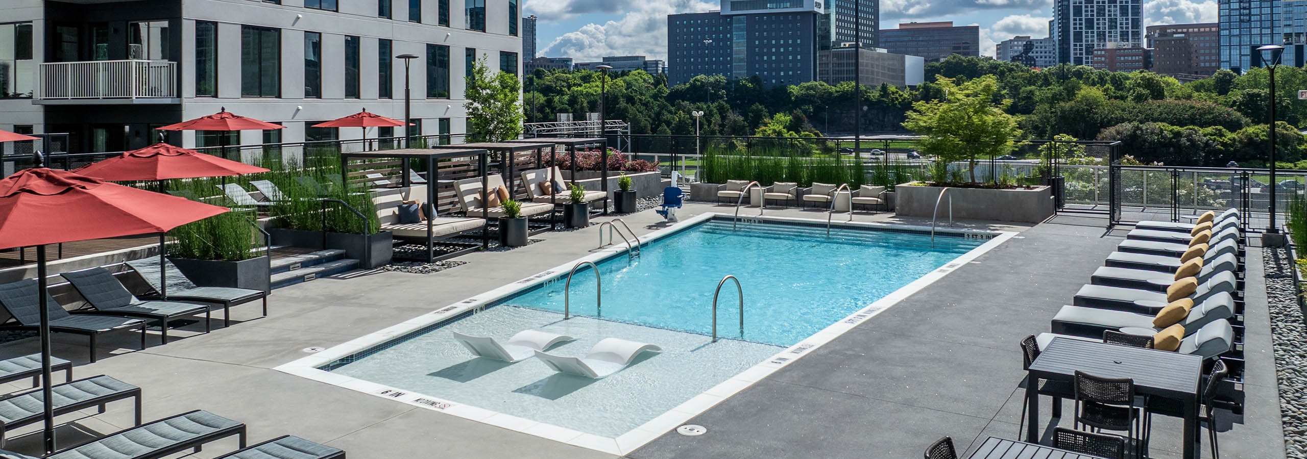 Daytime swimming pool with lounge seating and umbrellas at AMLI Atlantic Station.