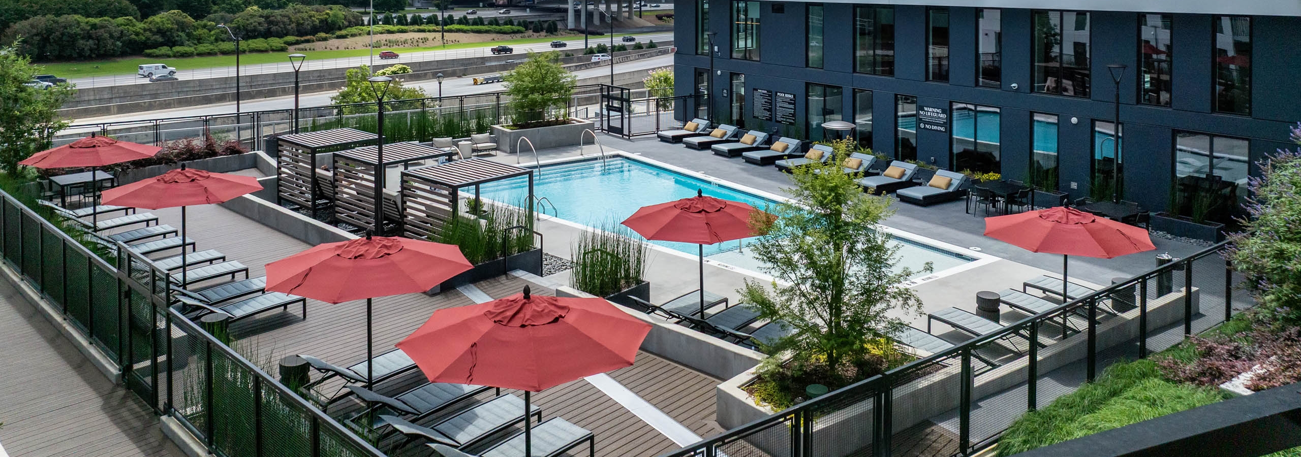 Swimming pool with umbrellas and daytime view of city skyline at AMLI Atlantic Station.