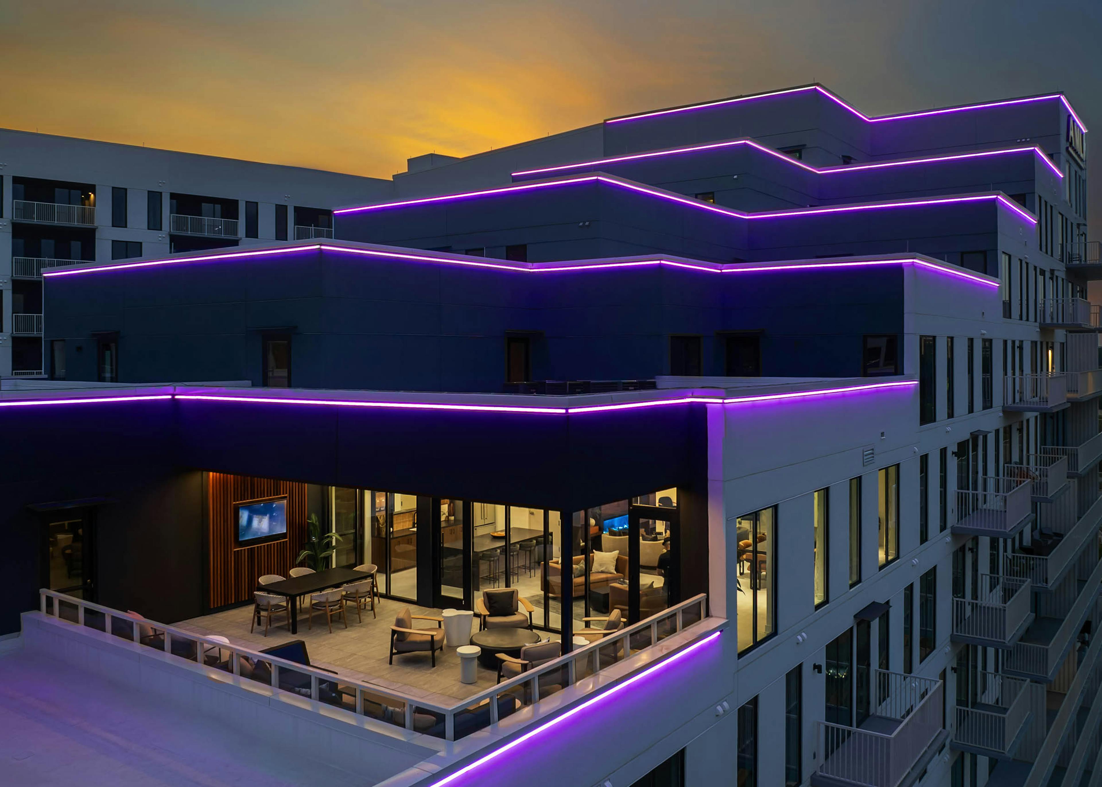 AMLI Atlantic Station sky lounge with stepped neon-lit balconies at sunset.