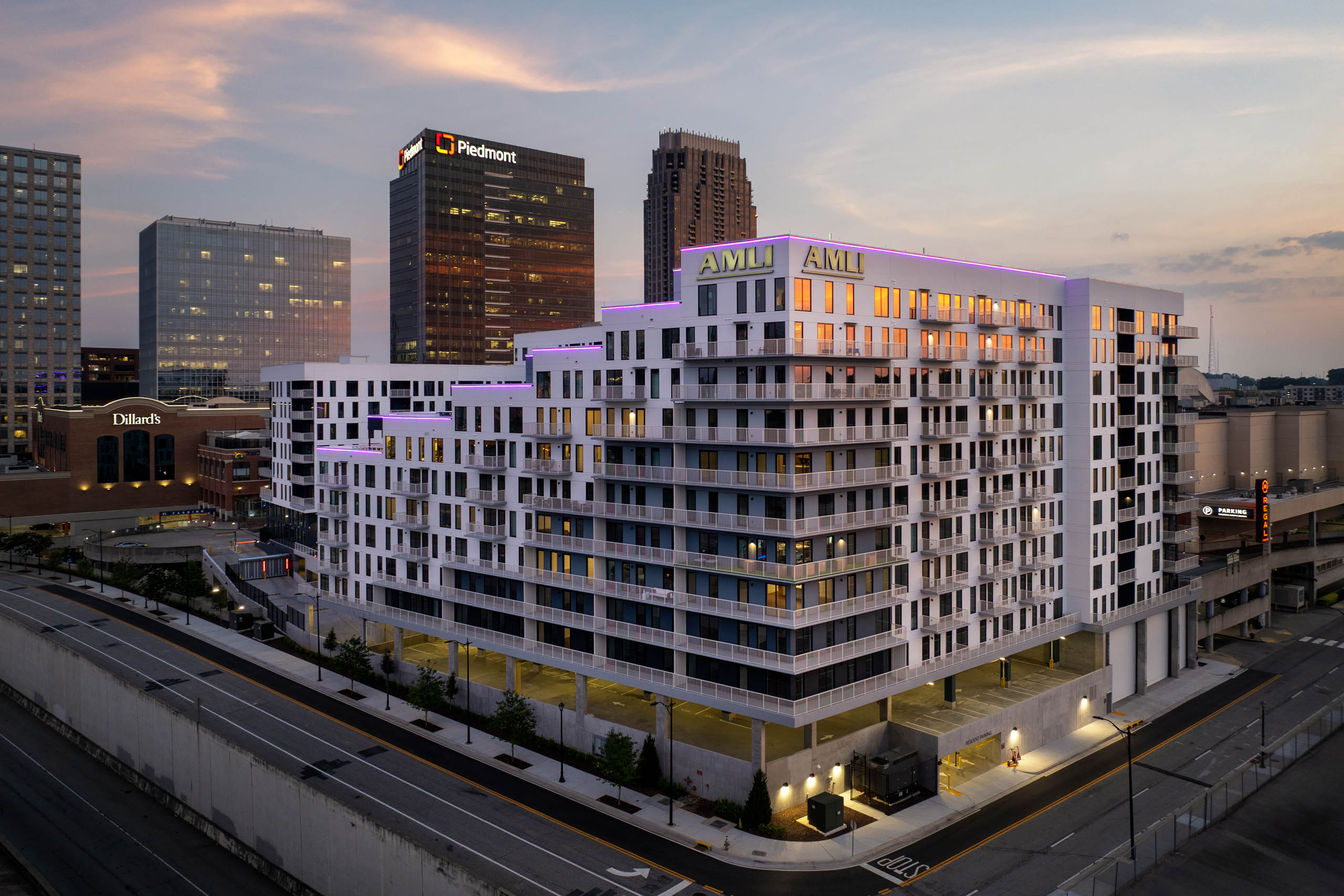 AMLI Atlantic Station exterior at sunset with balconies and street lighting.