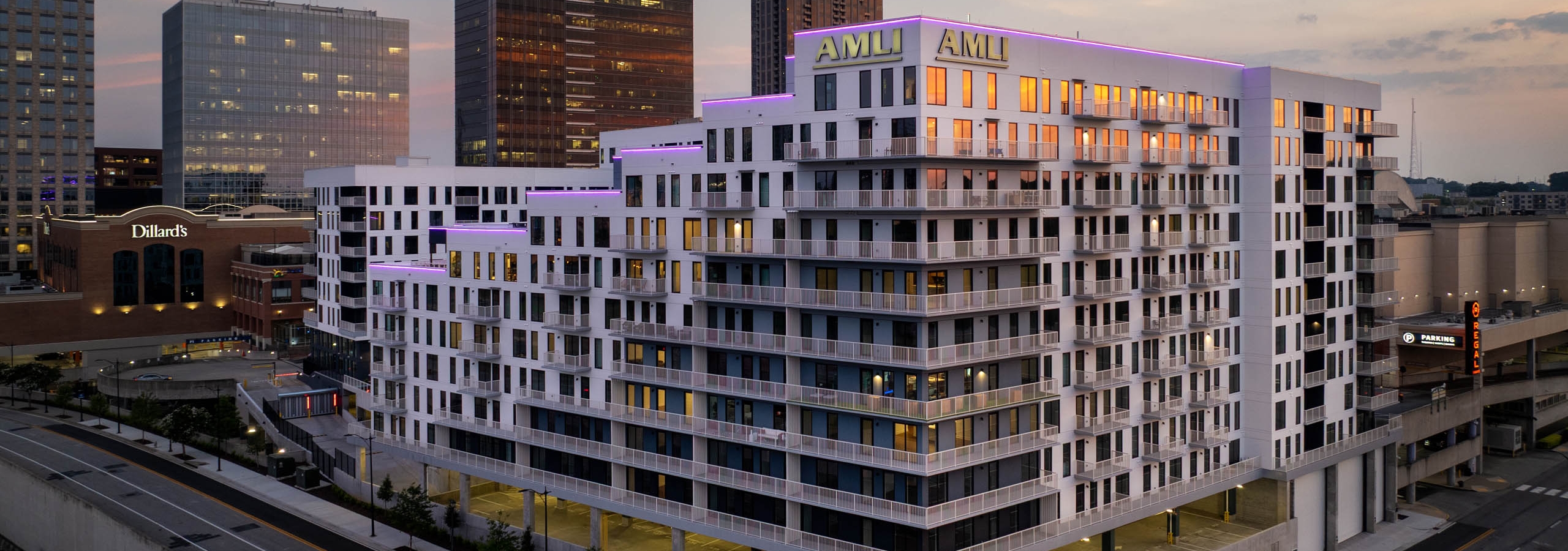 AMLI Atlantic Station exterior at sunset with balconies and street lighting.