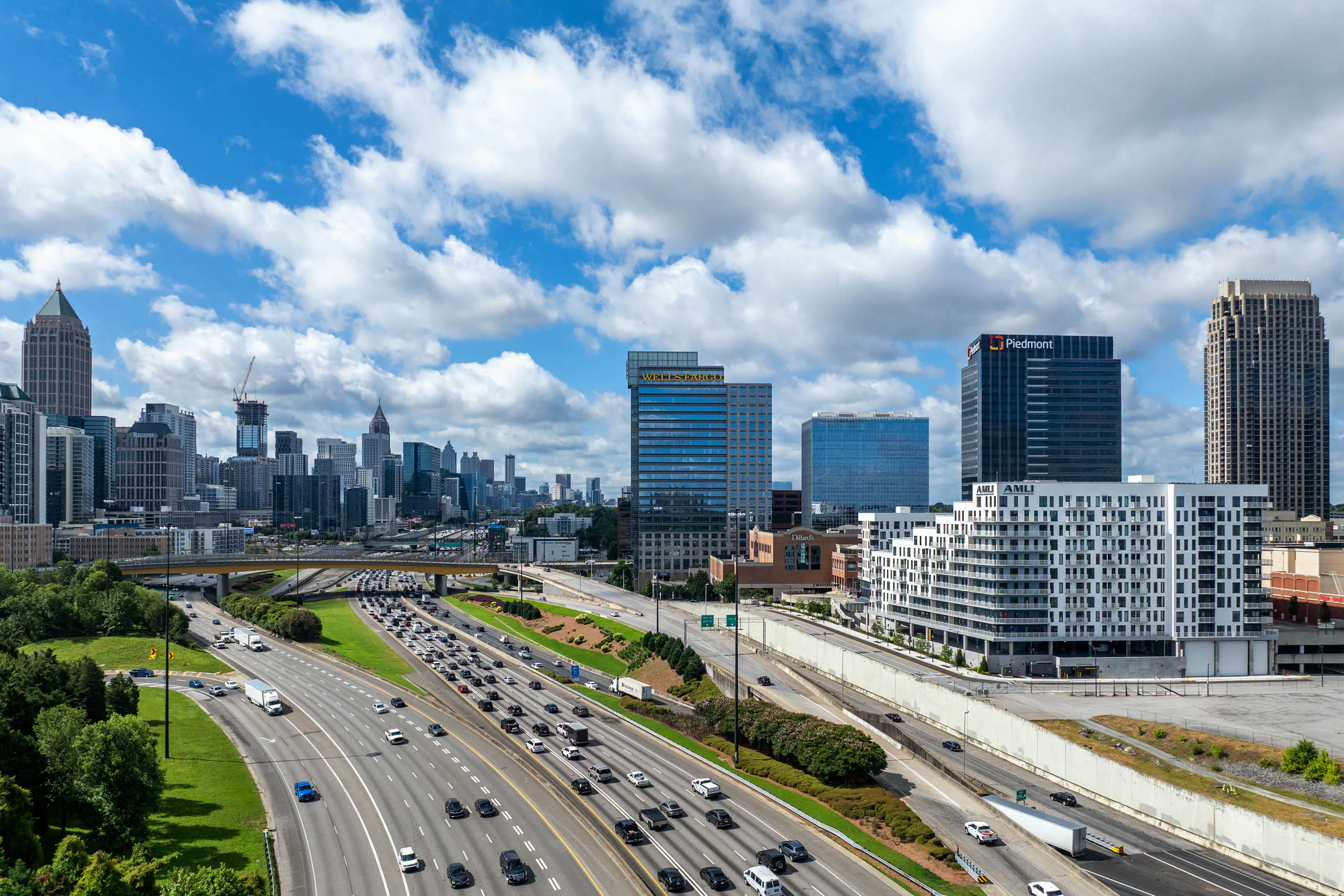 Daytime view of the city skyline over a highway with AMLI Atlantic Station in the foreground.