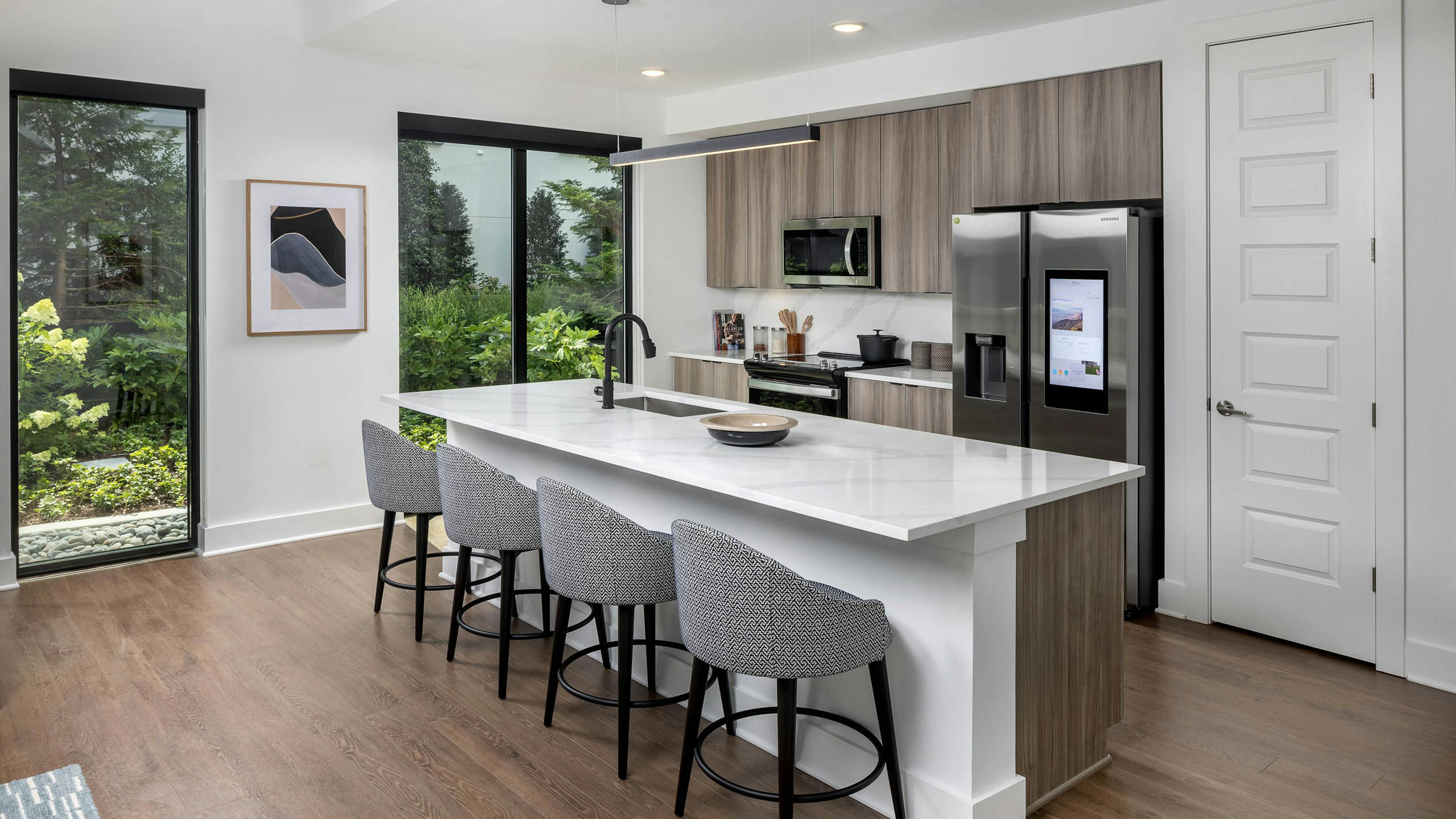 Kitchen with island at AMLI Atlantic Station with bar stools and stainless-steel appliances.