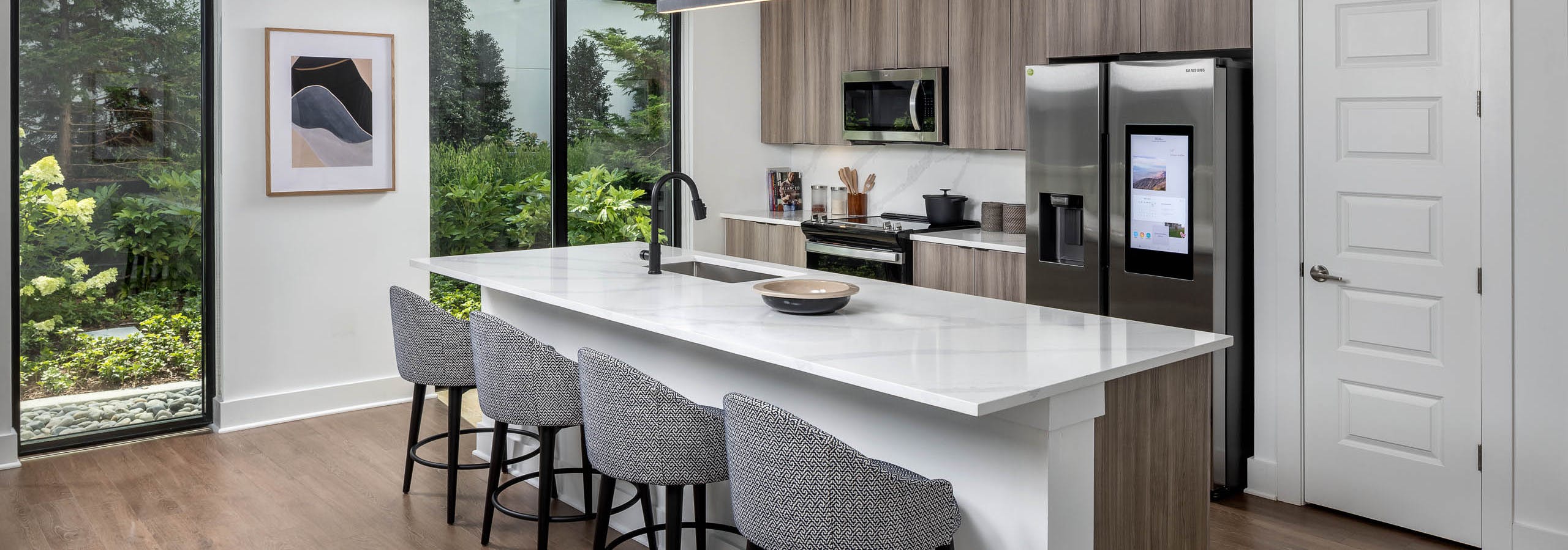 Kitchen with island at AMLI Atlantic Station with bar stools and stainless-steel appliances.