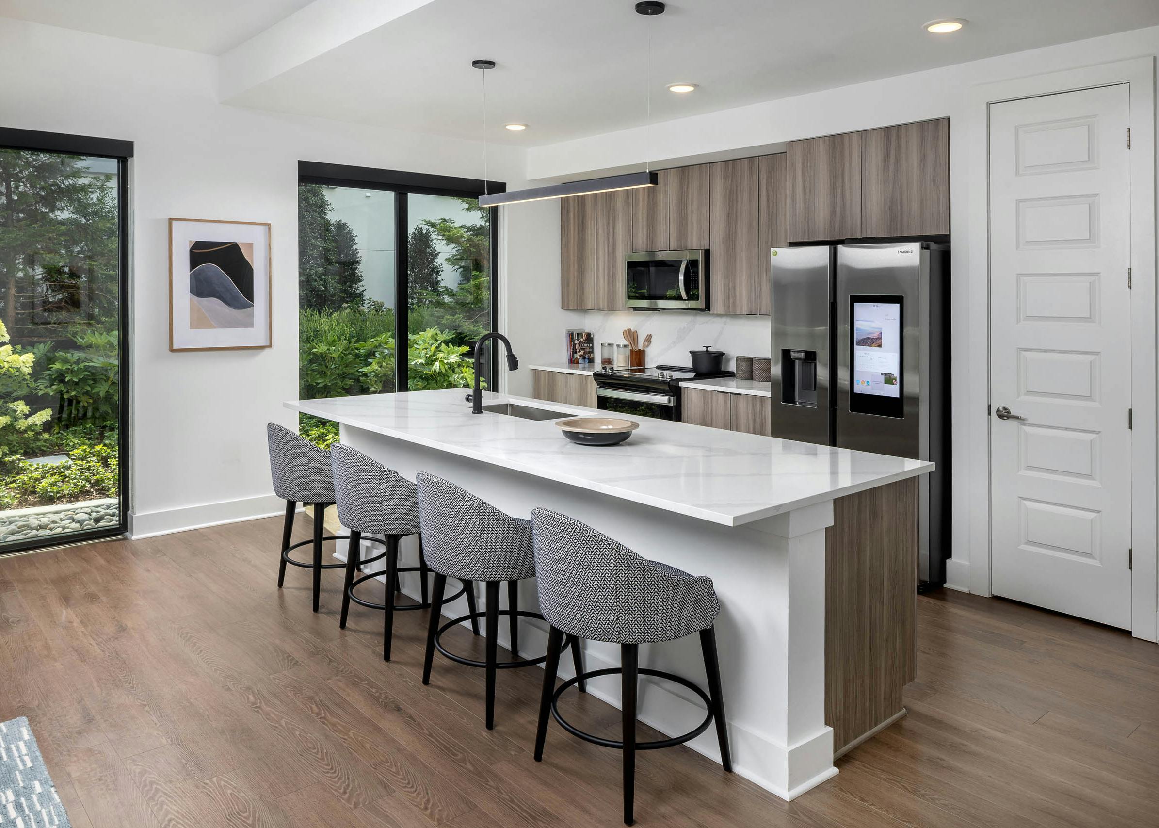 Kitchen with island at AMLI Atlantic Station with bar stools and stainless-steel appliances.