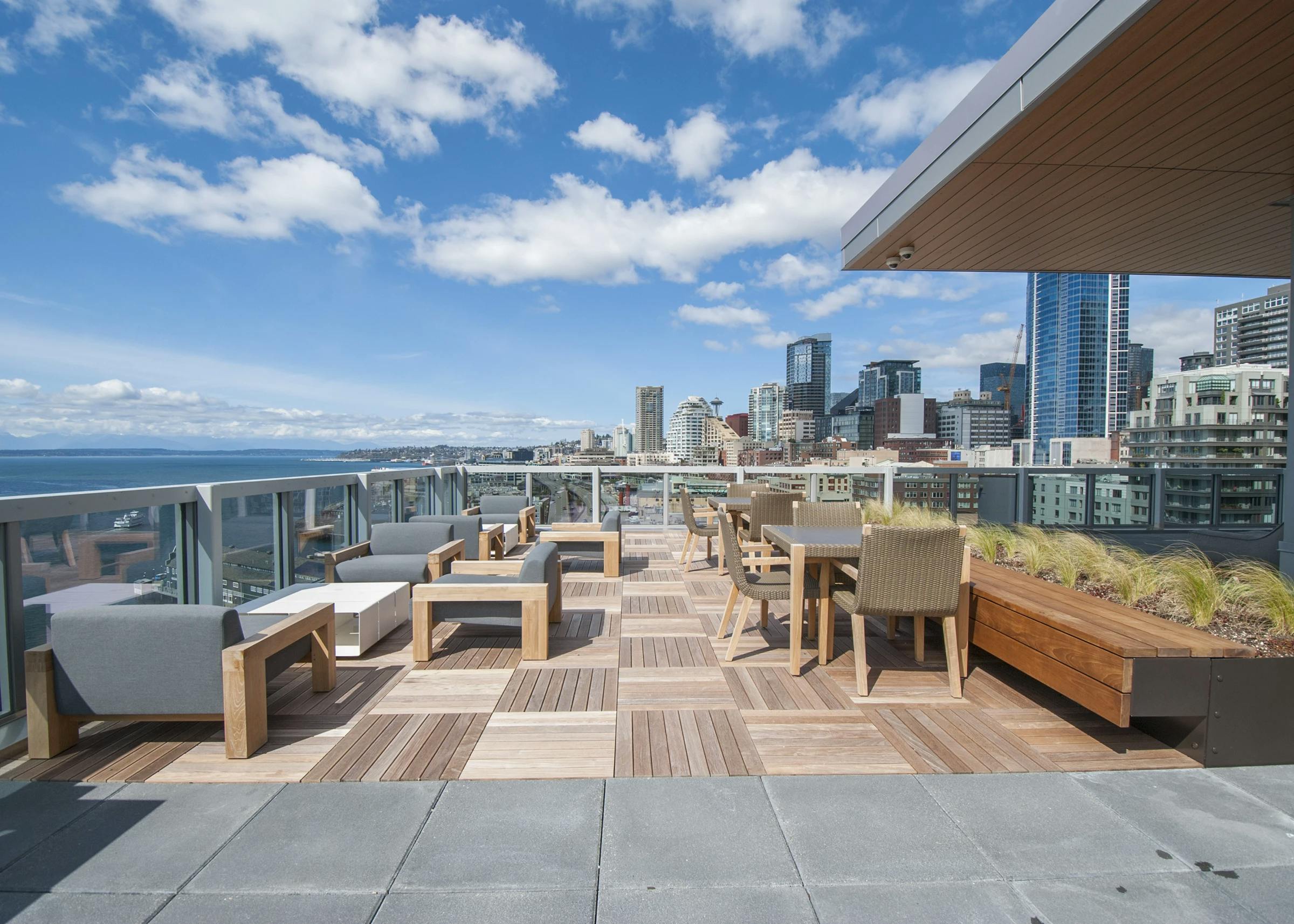 Rooftop deck at AMLI Waterfront apartments with wood furniture, skyline views, bayfront seating, and built-in planters.