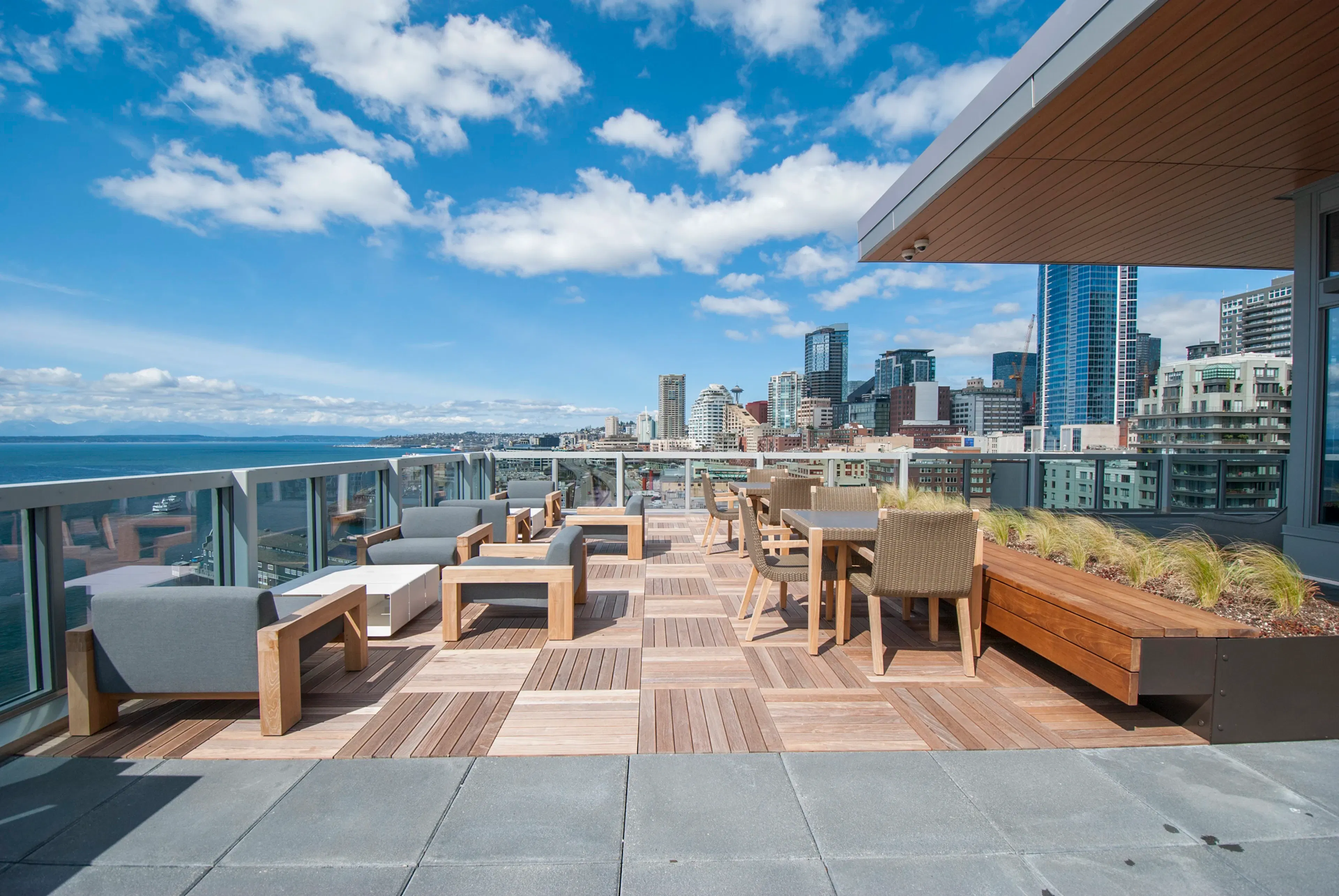 Rooftop deck at AMLI Waterfront apartments with wood furniture, skyline views, bayfront seating, and built-in planters.