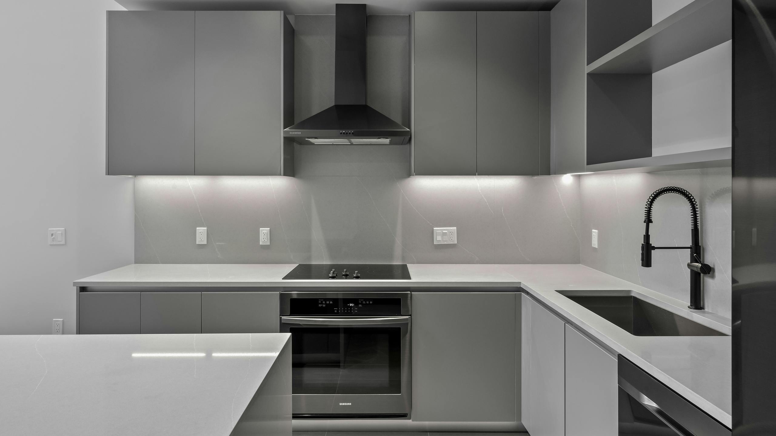 Modern kitchen at AMLI Wynwood with recessed lighting and stainless-steel appliances.