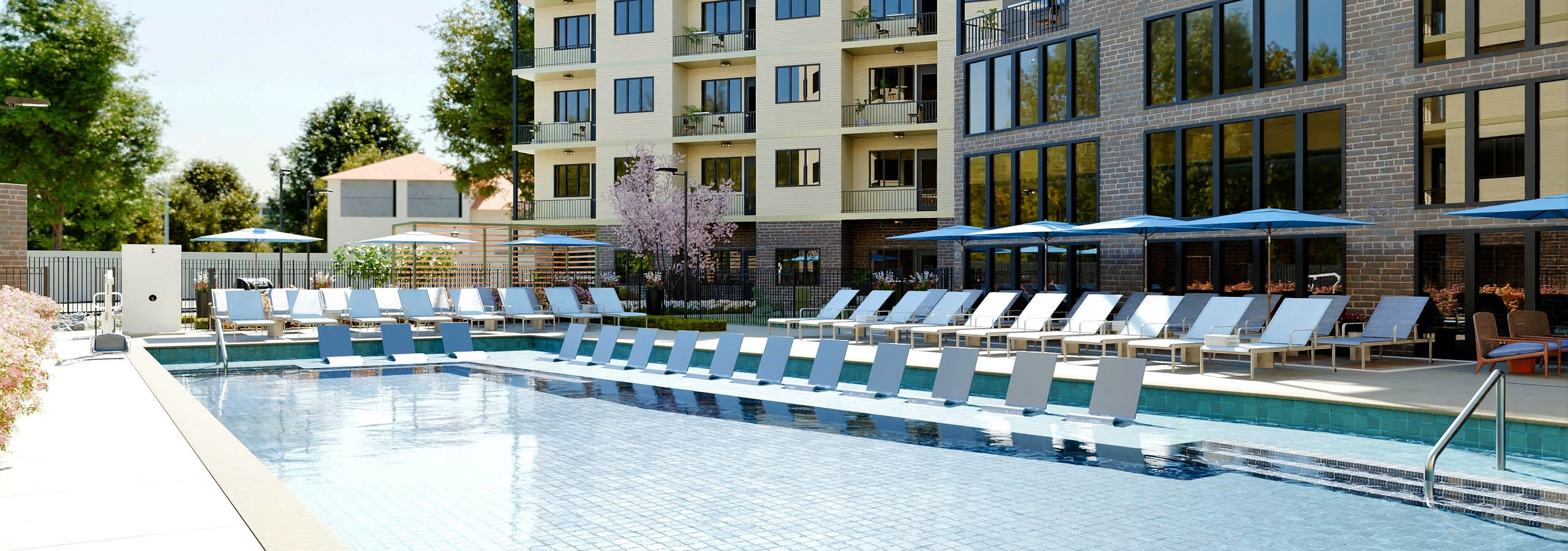 Swimming pool at AMLI Brookhaven with lounge chairs and umbrellas.