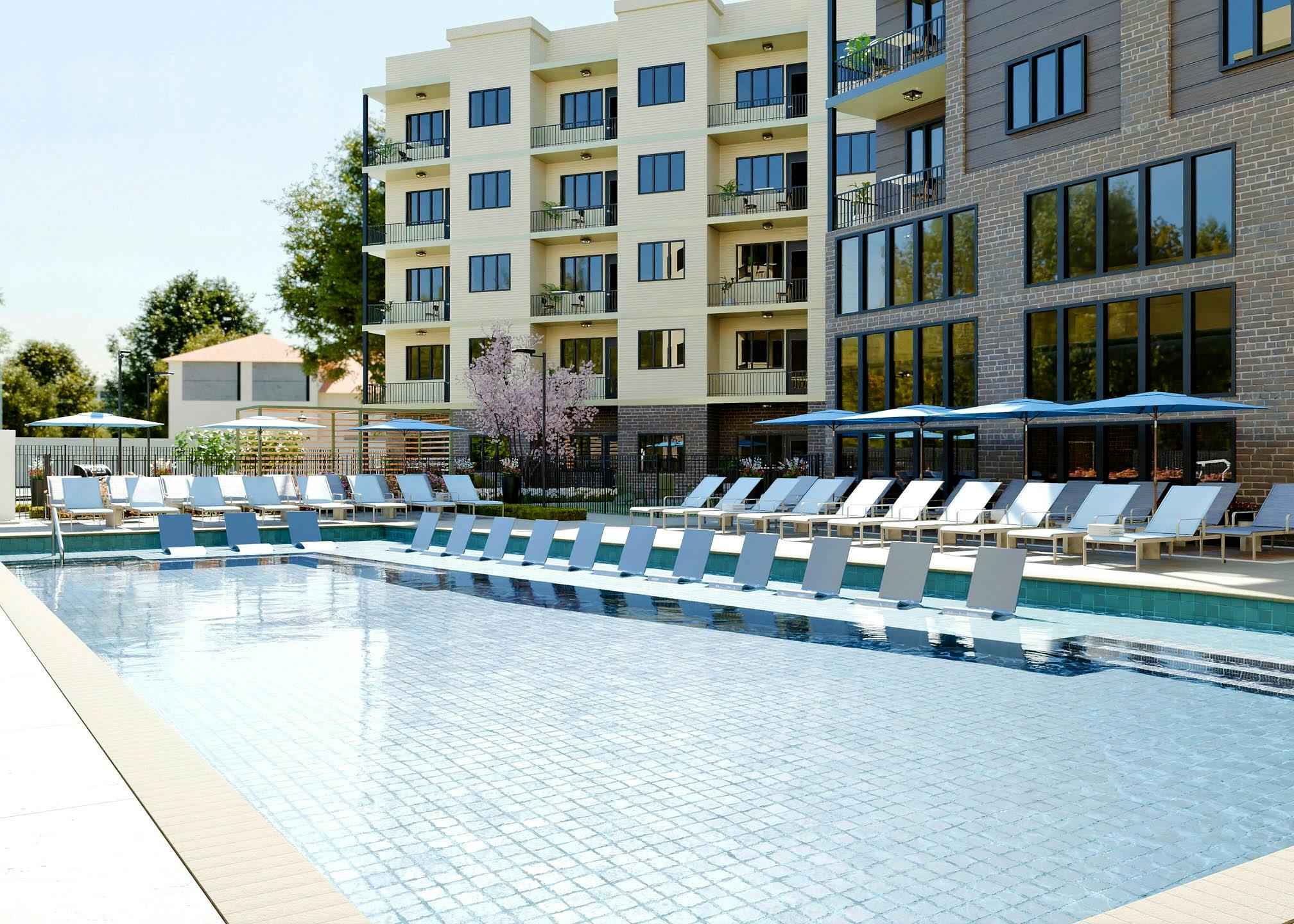 Swimming pool at AMLI Brookhaven with lounge chairs and umbrellas.