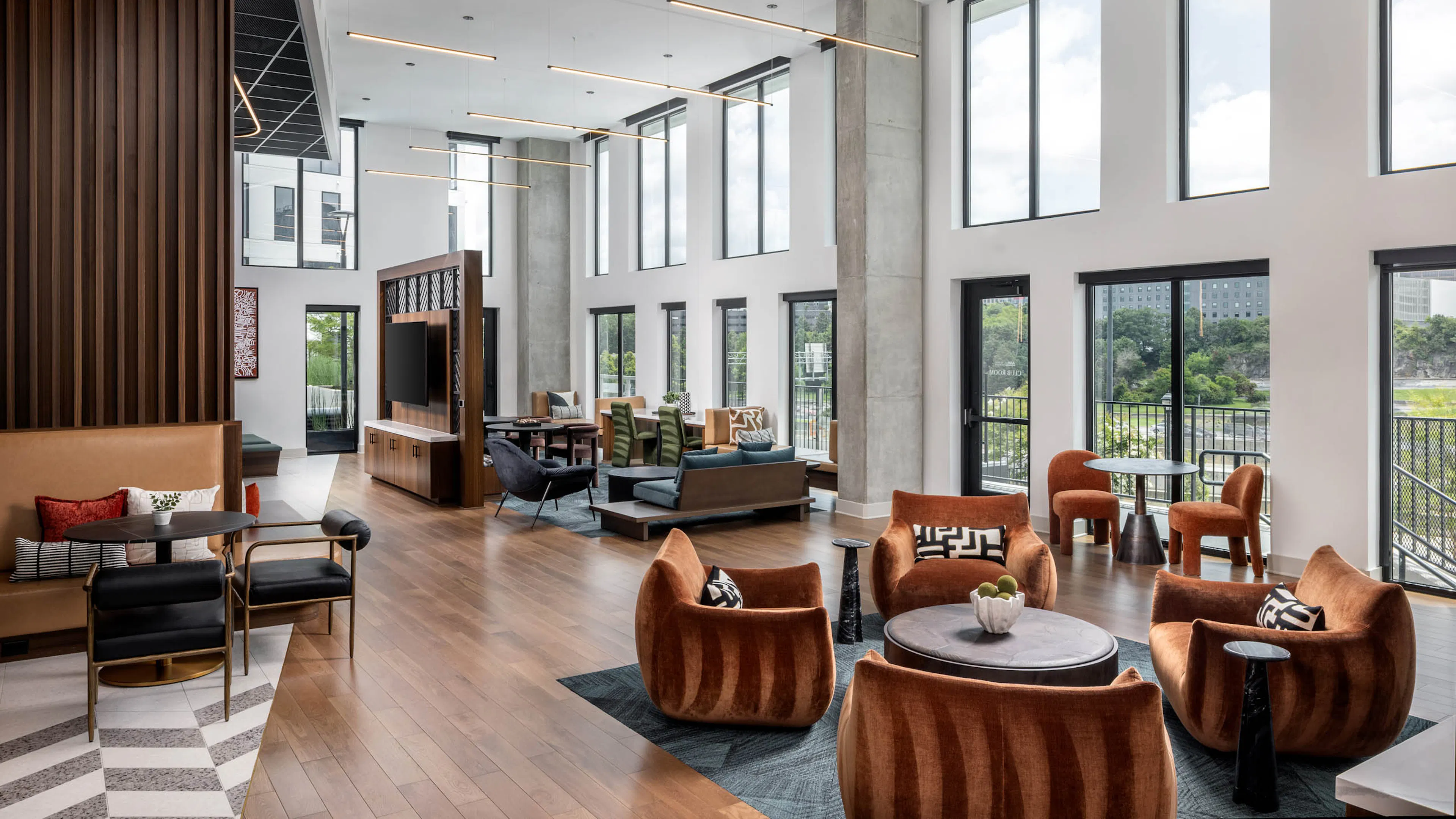 The clubroom at AMLI Atlantic Station with chairs and high ceilings.