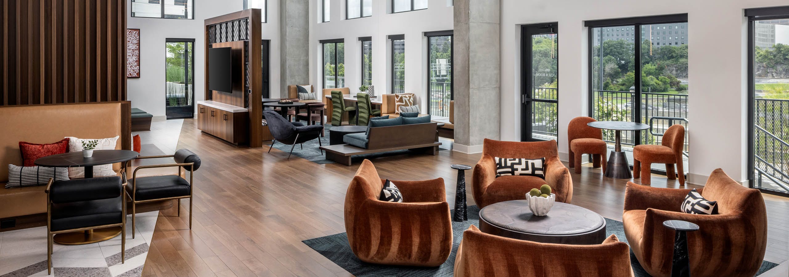 The clubroom at AMLI Atlantic Station with chairs and high ceilings.