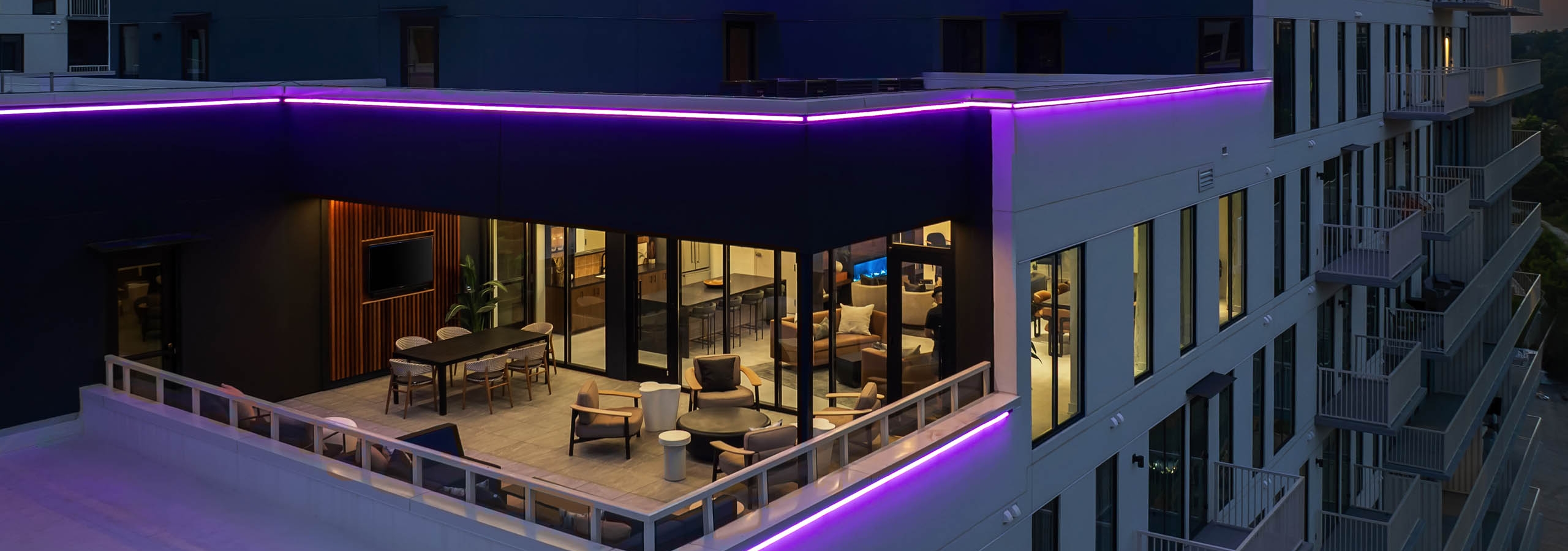 AMLI Atlantic Station sky lounge with stepped neon-lit balconies at sunset.