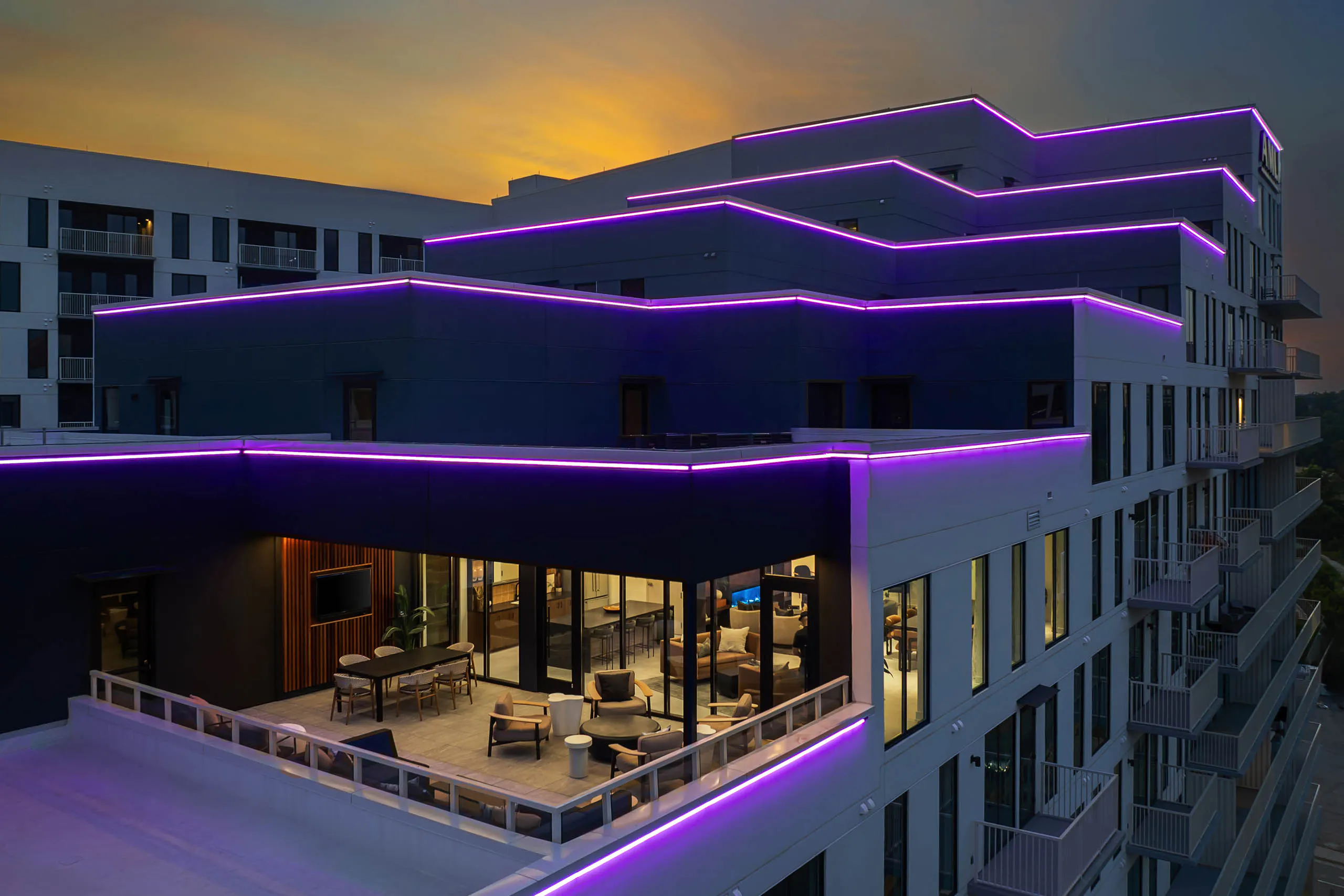 AMLI Atlantic Station sky lounge with stepped neon-lit balconies at sunset.