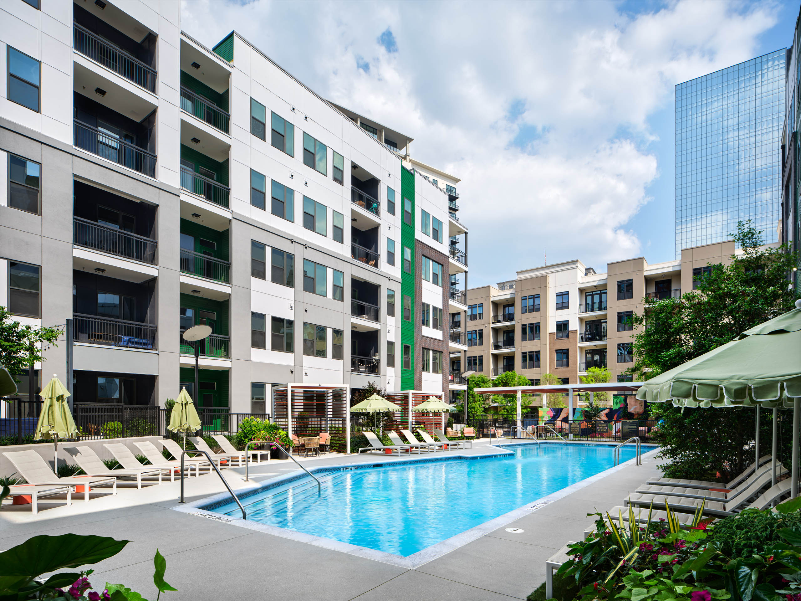Swimming pool at AMLI Flatiron surrounded by lounge seating and plants.