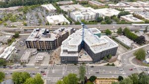 Aerial photo of construction at AMLI Redmond Way apartments with a large crane and siding being installed