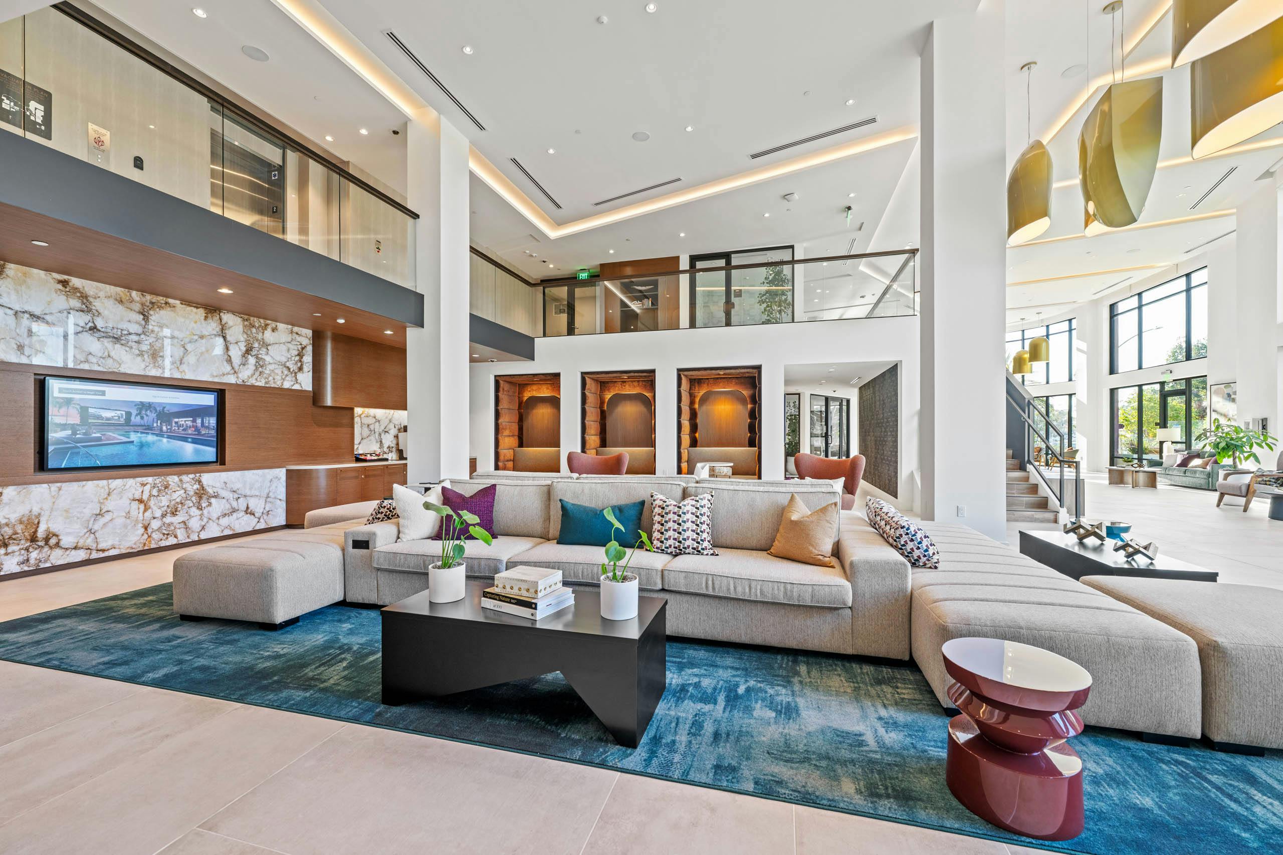 Lobby at AMLI Aero with multiple seating options with a geometric shaped couch and plush pods with bench seating.