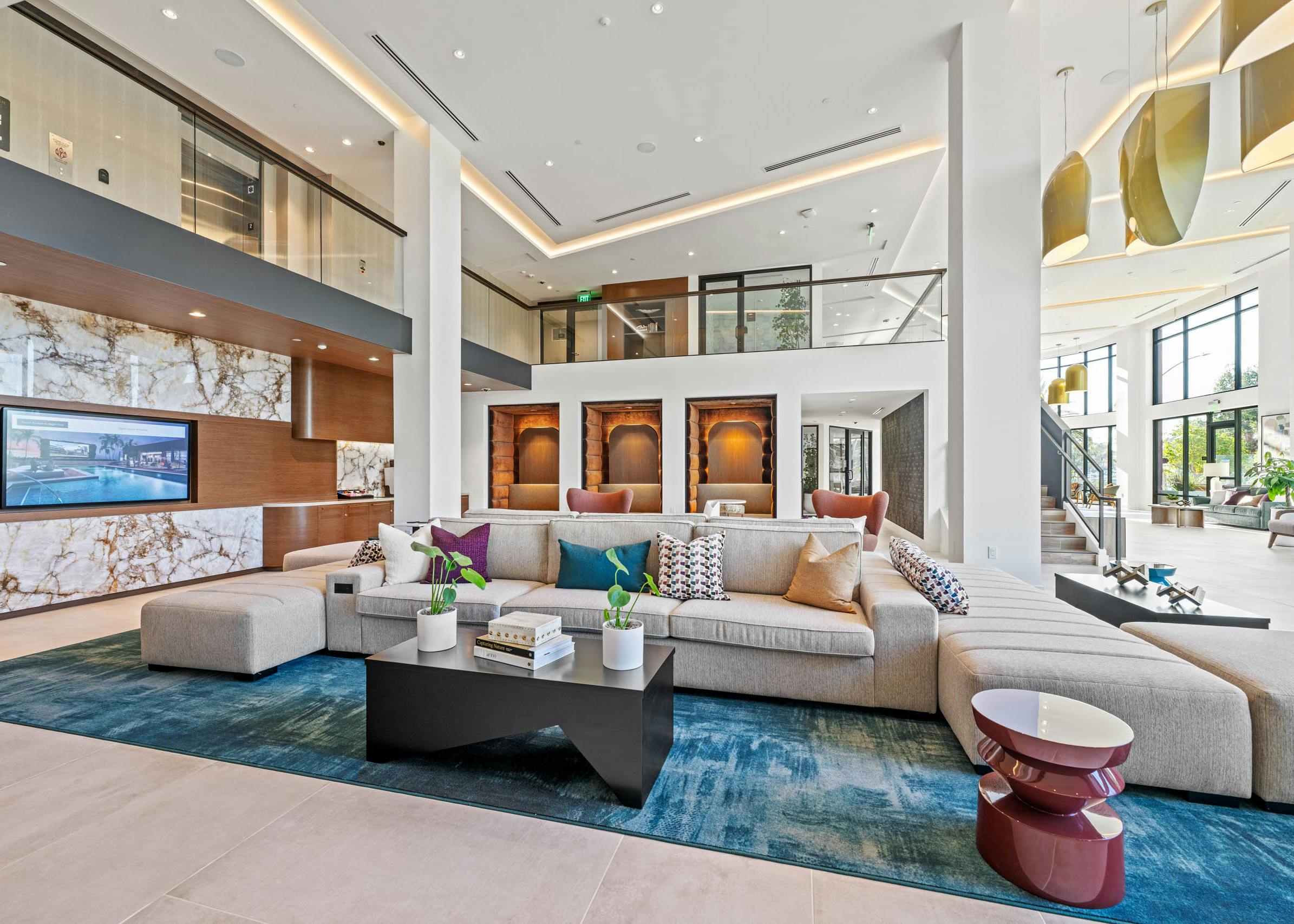 Lobby at AMLI Aero with multiple seating options with a geometric shaped couch and plush pods with bench seating.