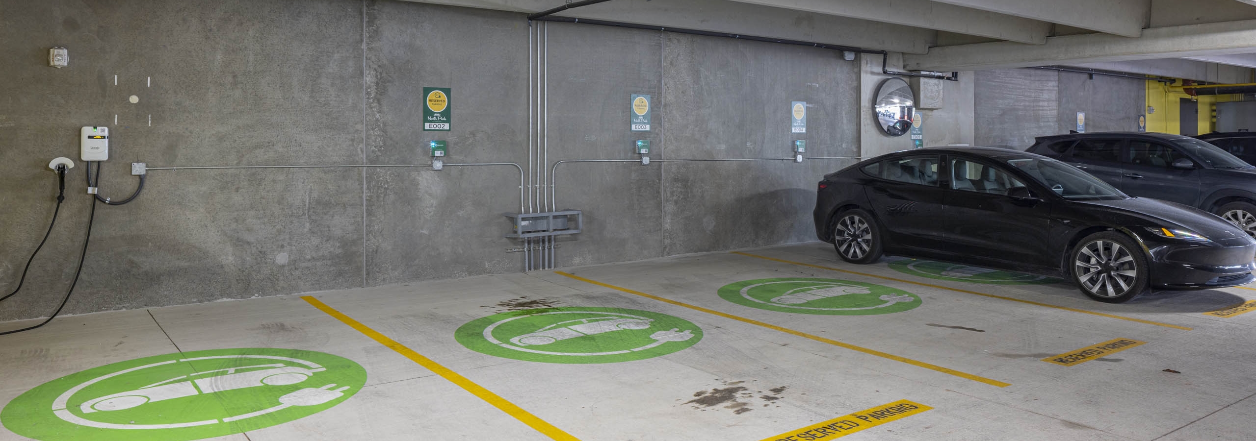 EV charging area at AMLI North Park apartment community parking garage showing three reservable electric charging stations