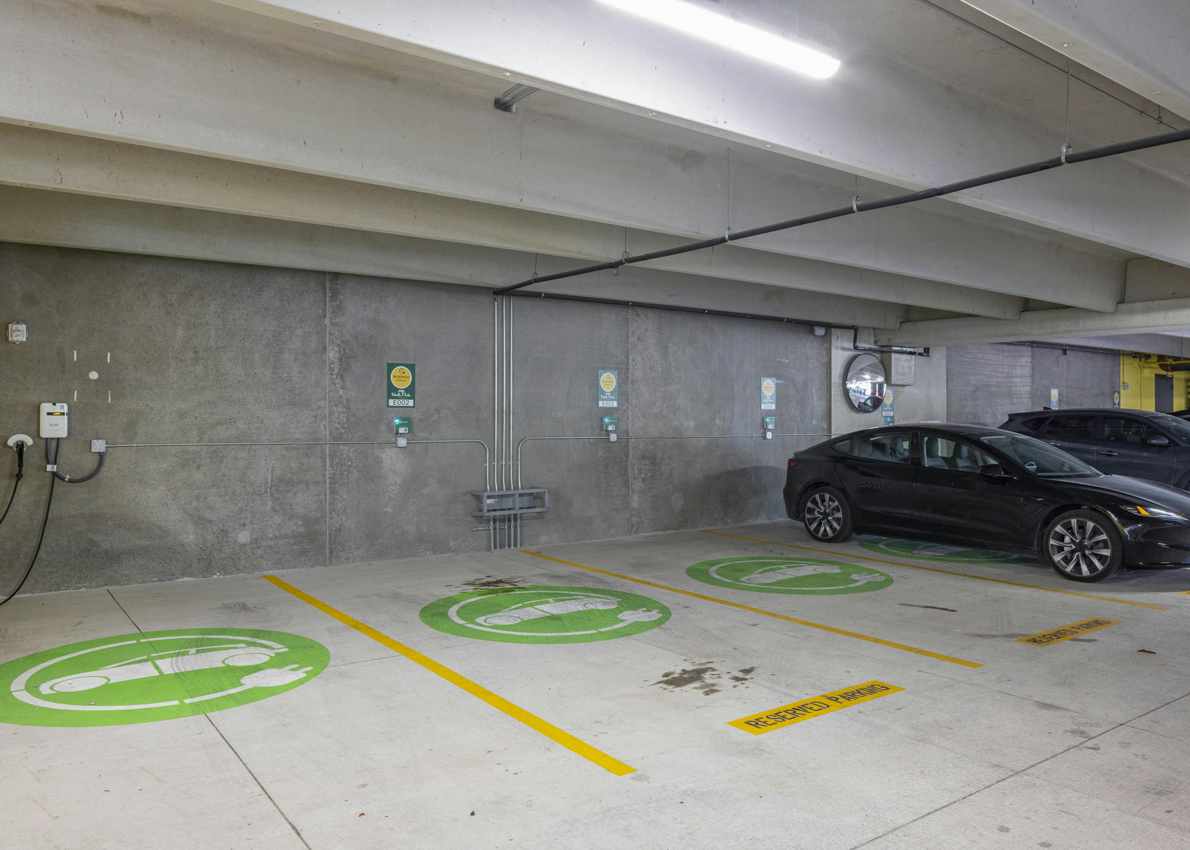 EV charging area at AMLI North Park apartment community parking garage showing three reservable electric charging stations